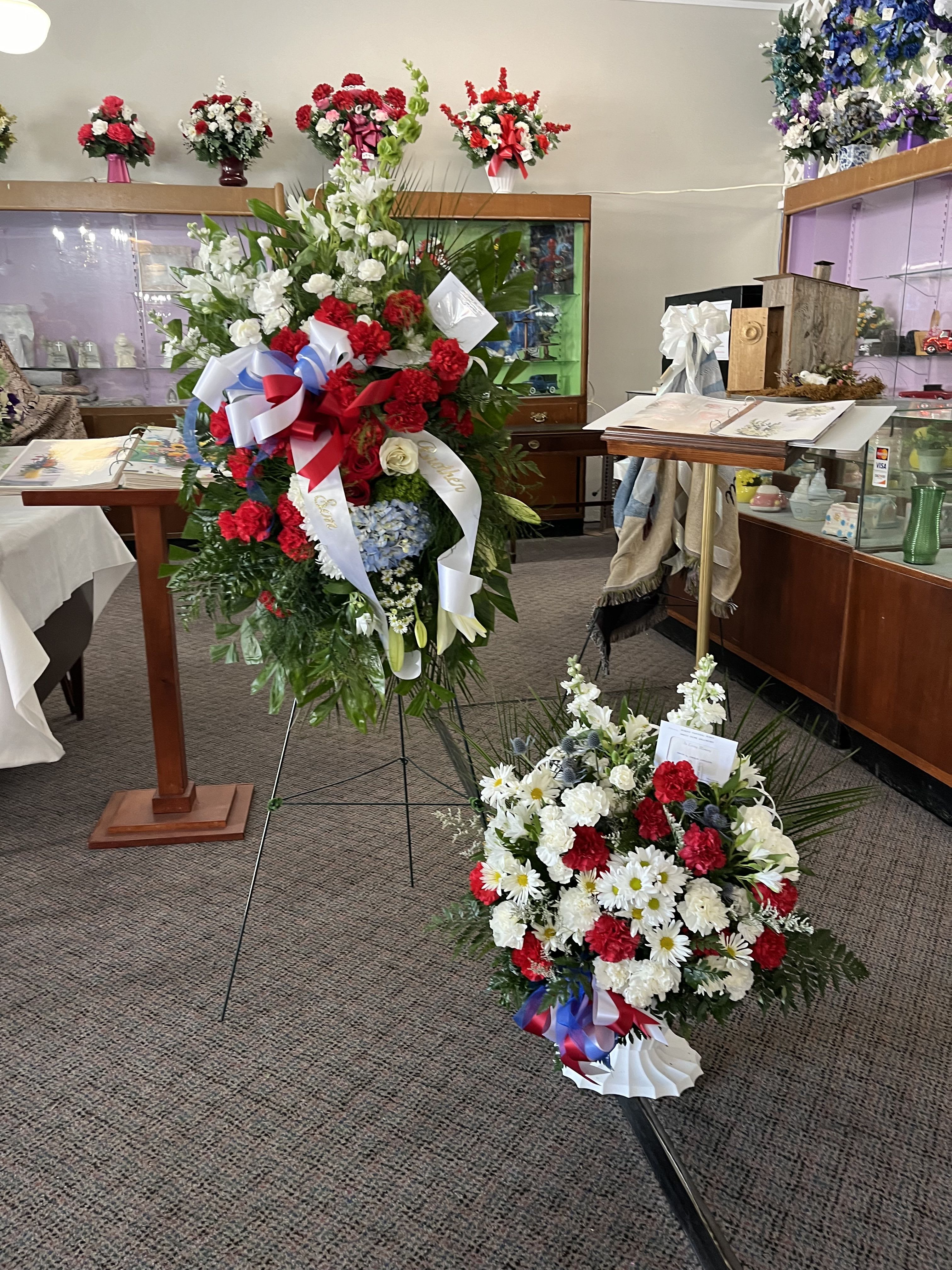 Two large floral standing sprays with red, white, and blue flowers