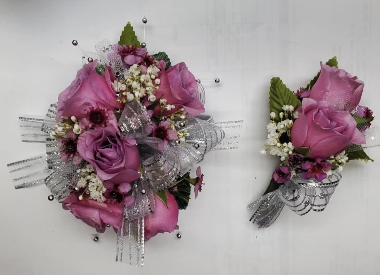 Pink rose corsage and matching boutonniere with silver ribbon