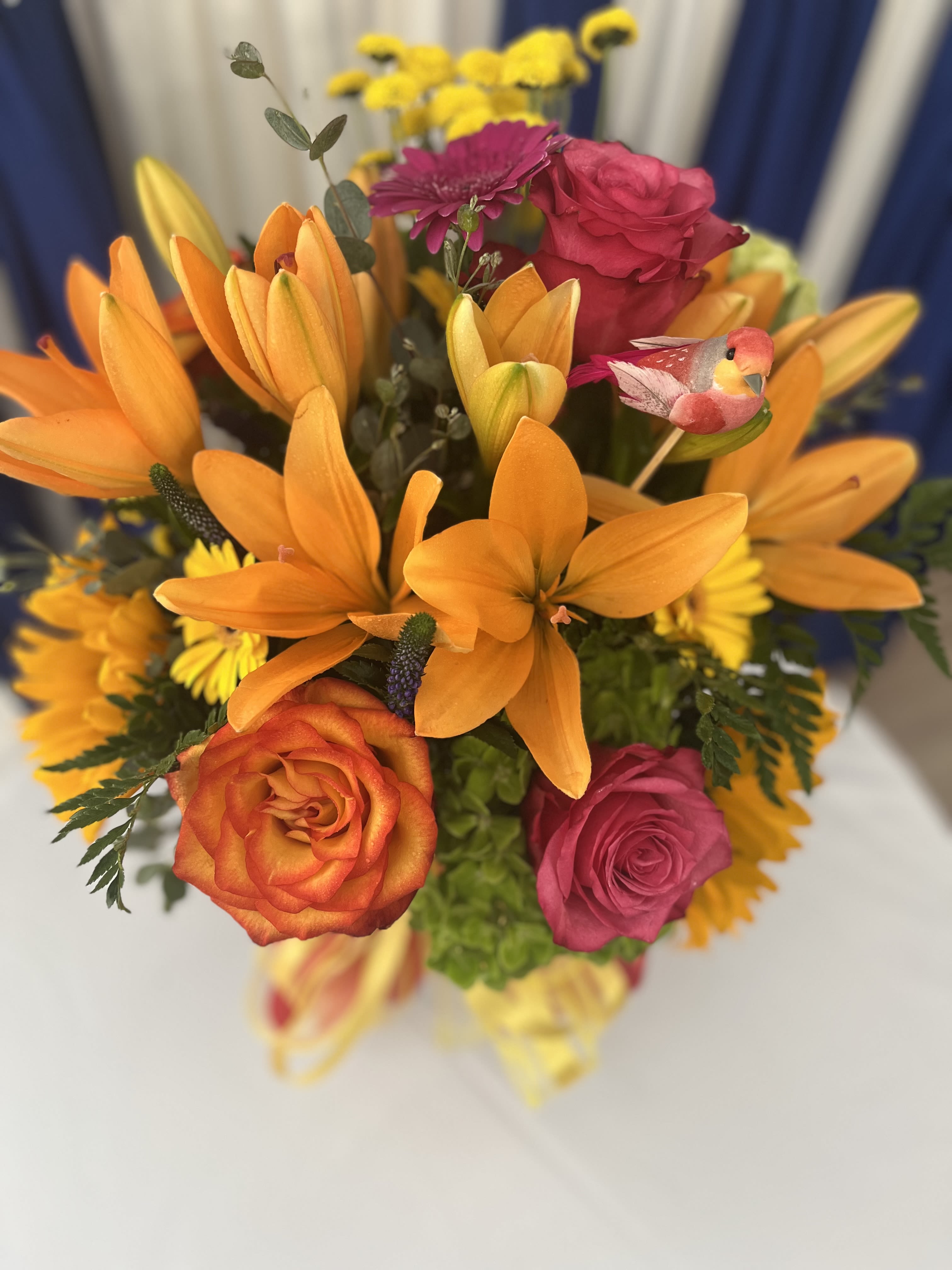 Bright Blooms  - This arrangement is sure to brighten your mood! Orange lilies are so colorful and so are the gorgeous roses! Purchase with your next order! (Price of the bird is included) 