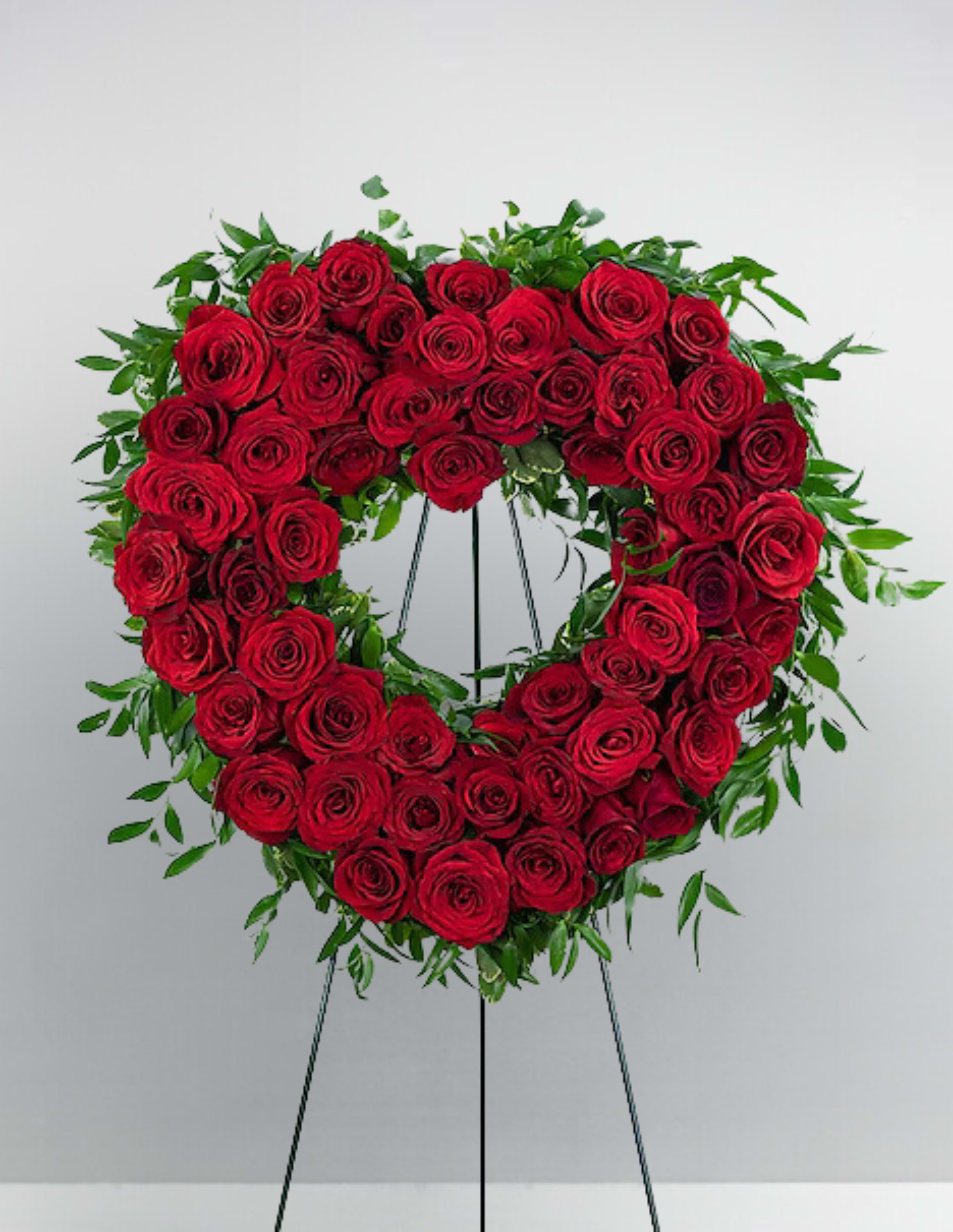 Heart-shaped wreath of red roses on a standing easel