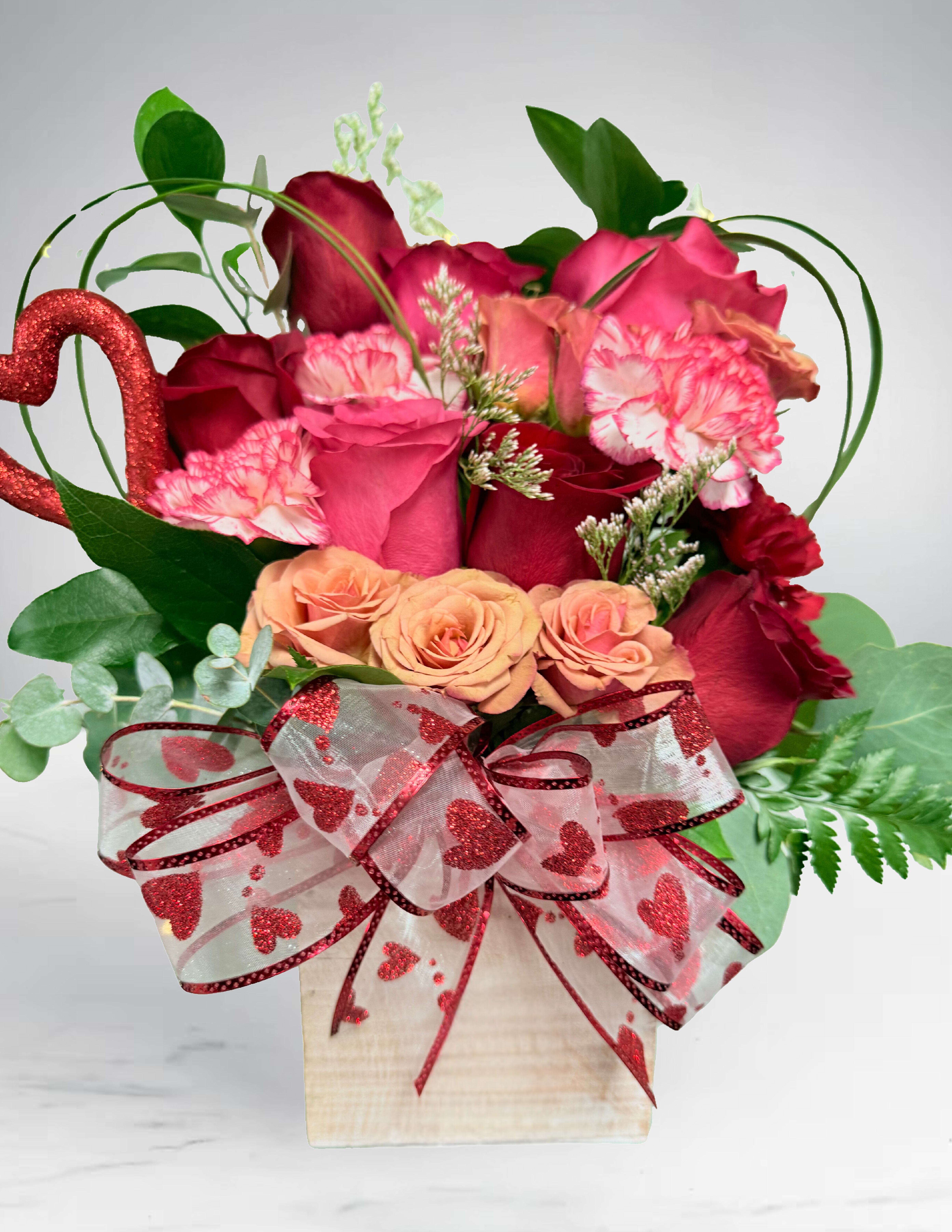 Heart-themed bouquet of red and pink roses in a white box