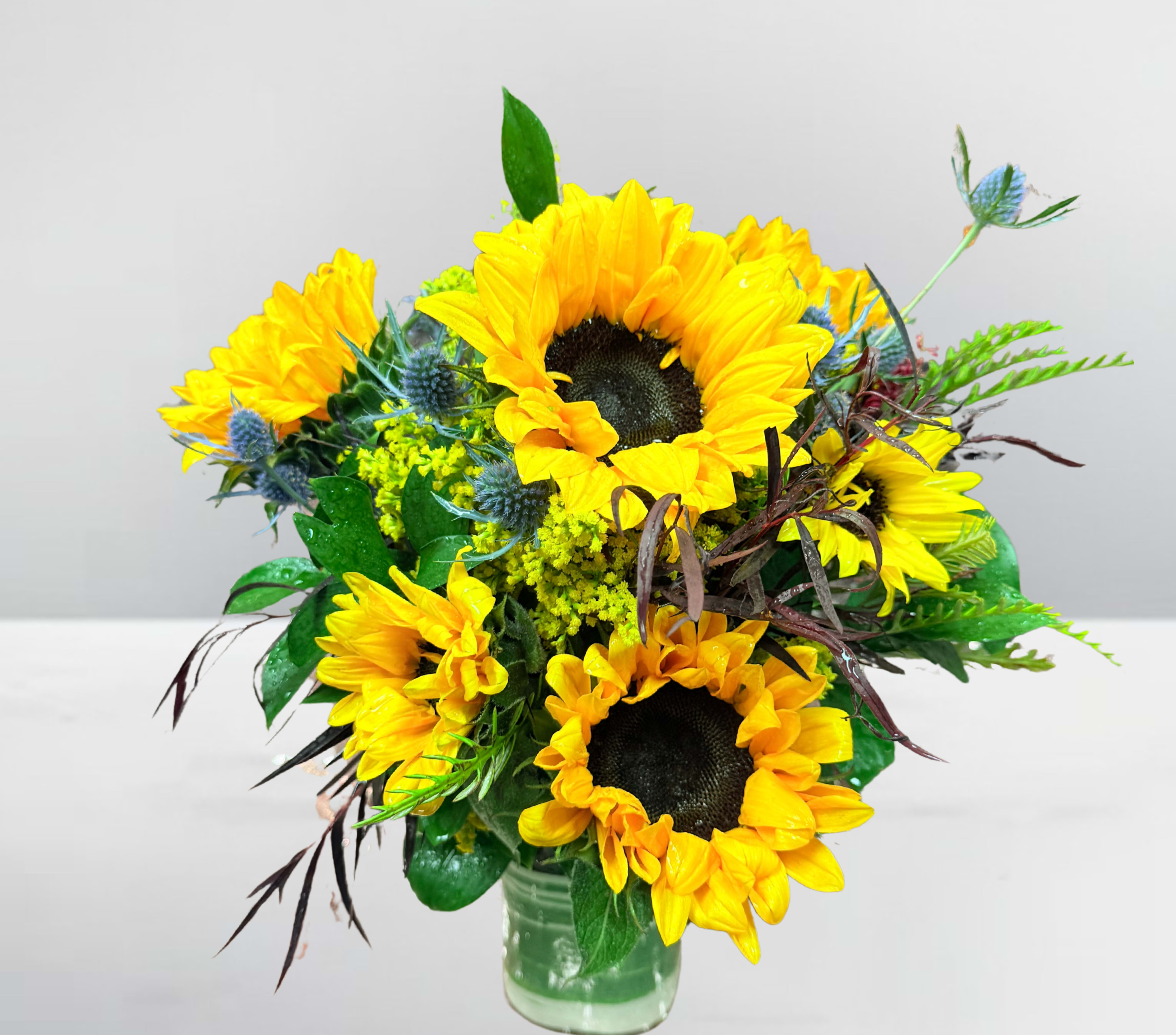 Bouquet of yellow sunflowers in a clear glass vase