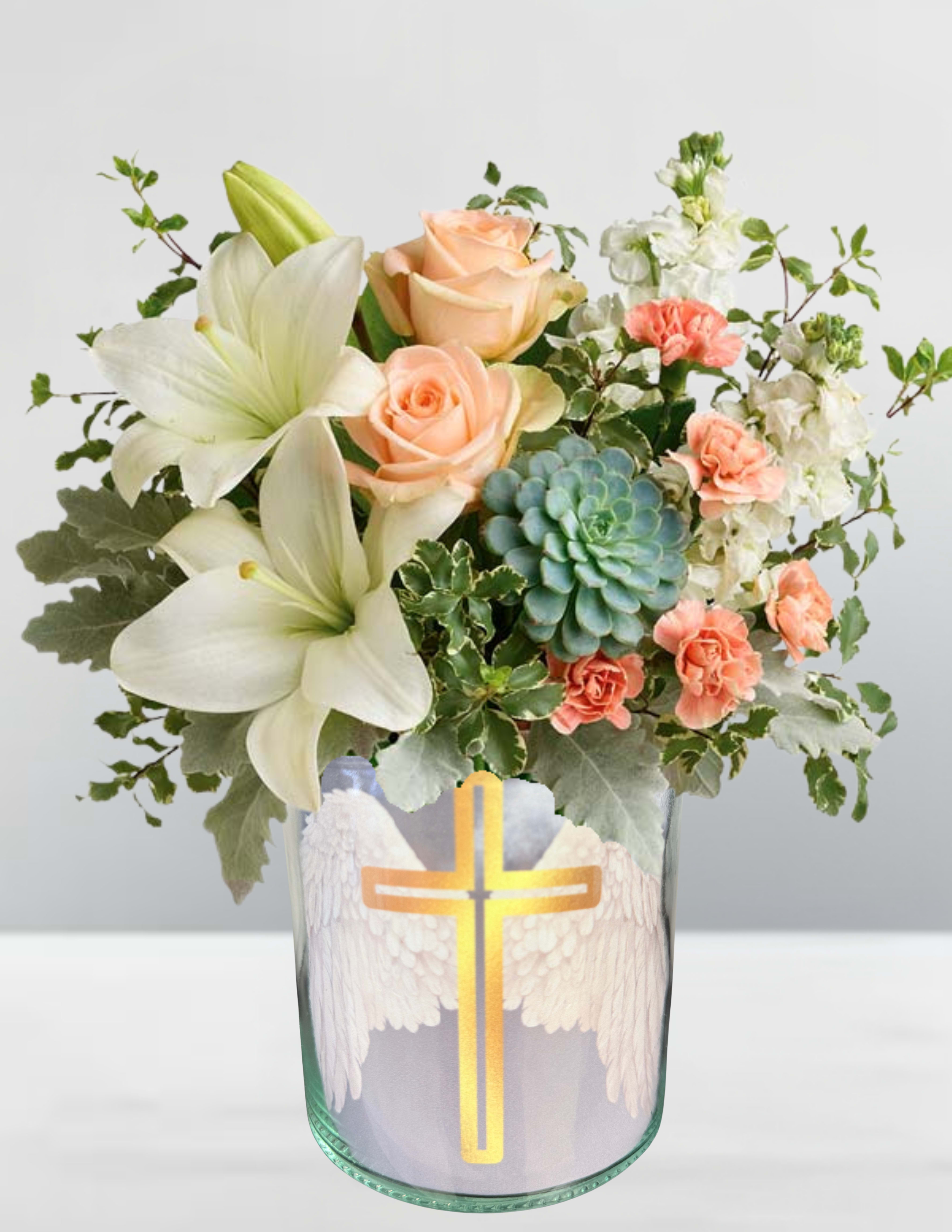 Peach roses and white lilies in a glass vase with a cross design