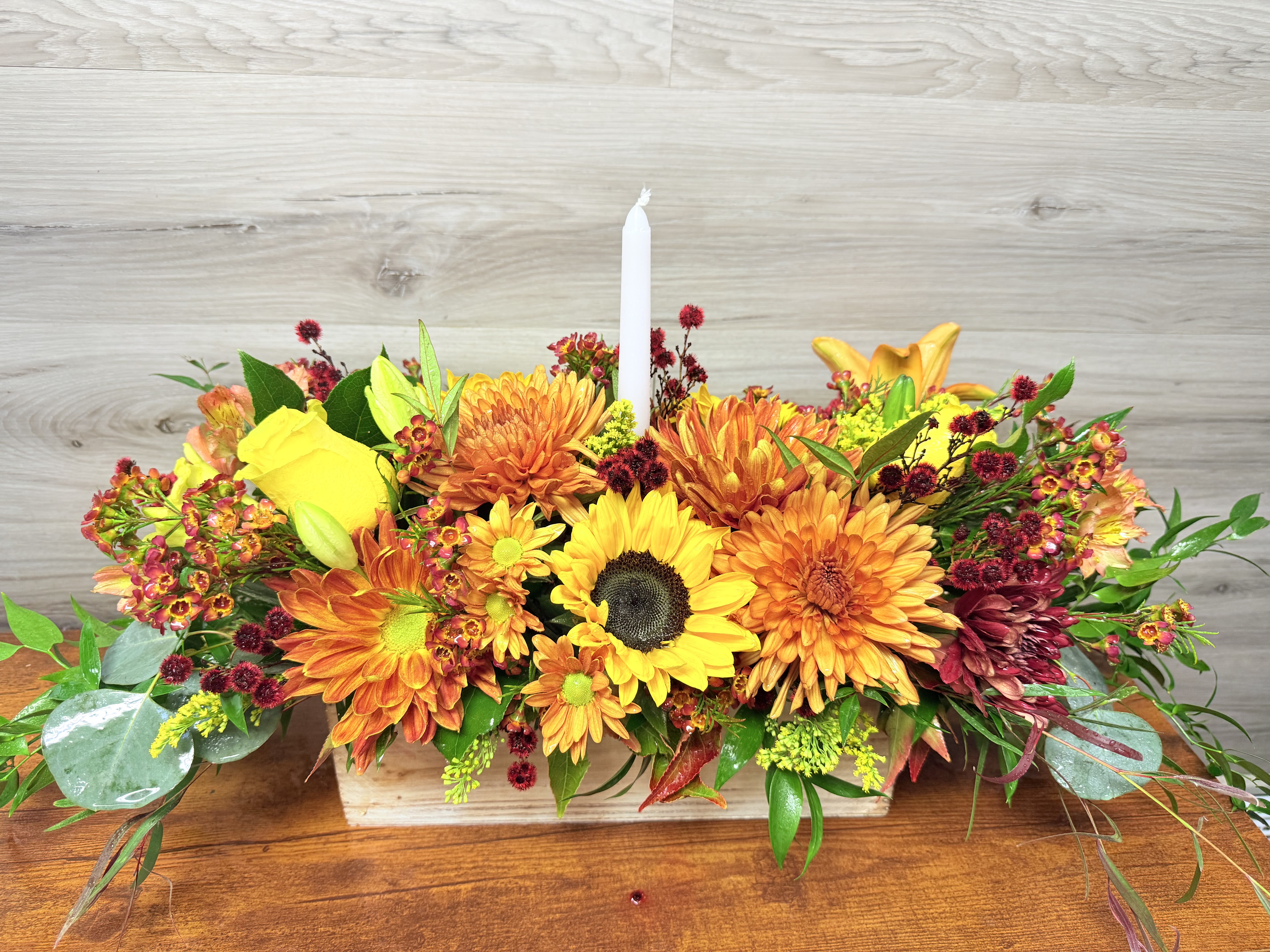Autumn floral centerpiece with a white taper candle