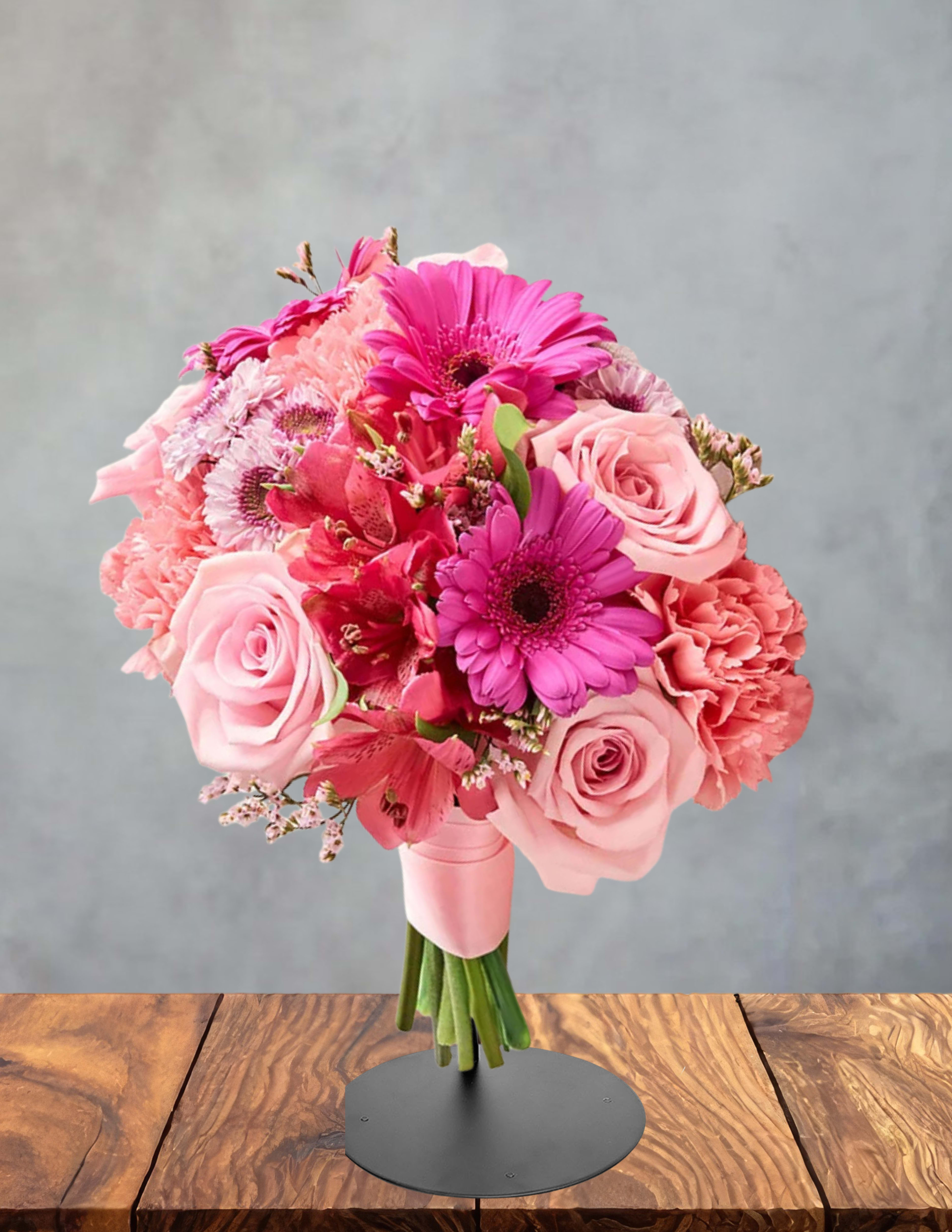 Pink bouquet of roses, gerbera daisies, and carnations on a stand