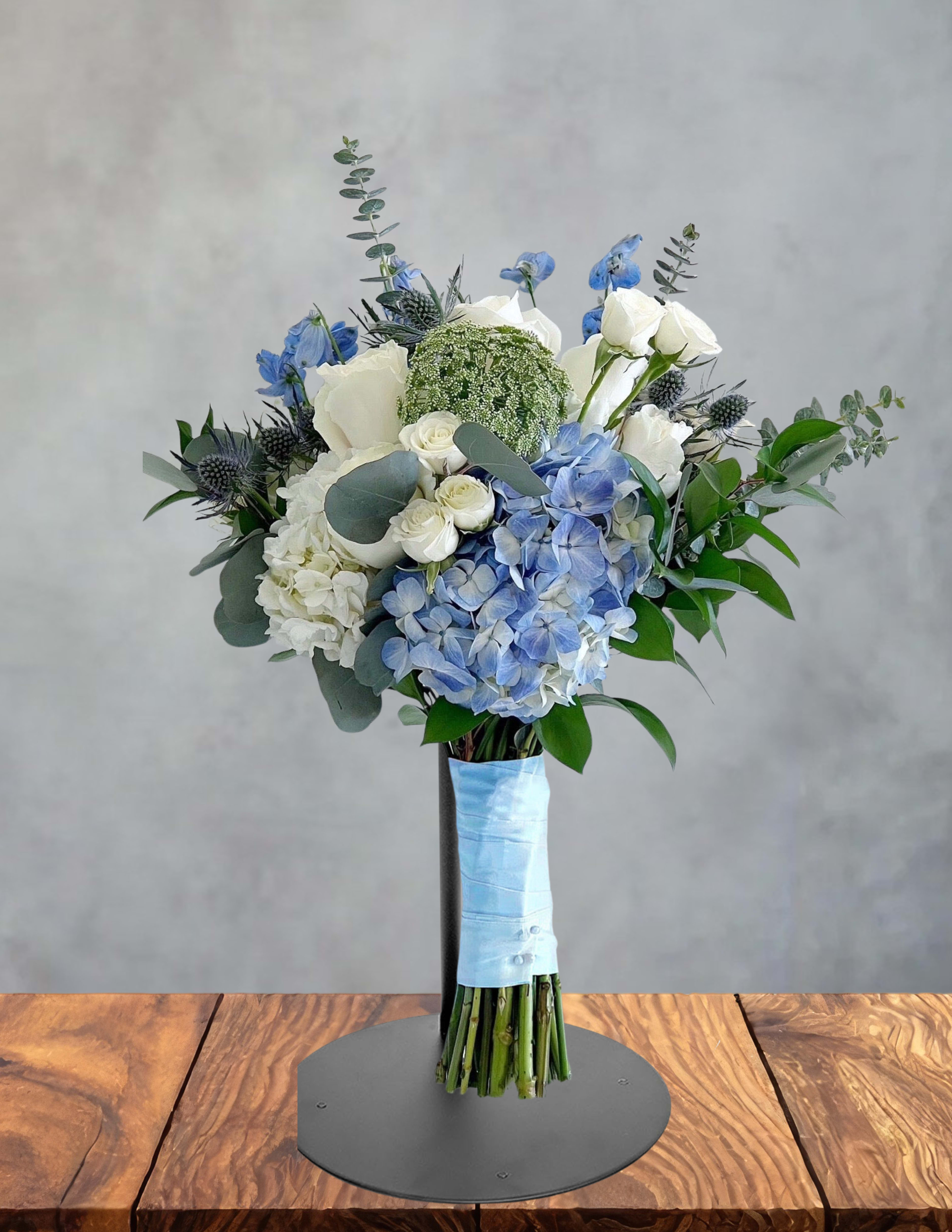 Blue and white bouquet with hydrangeas and roses on a stand