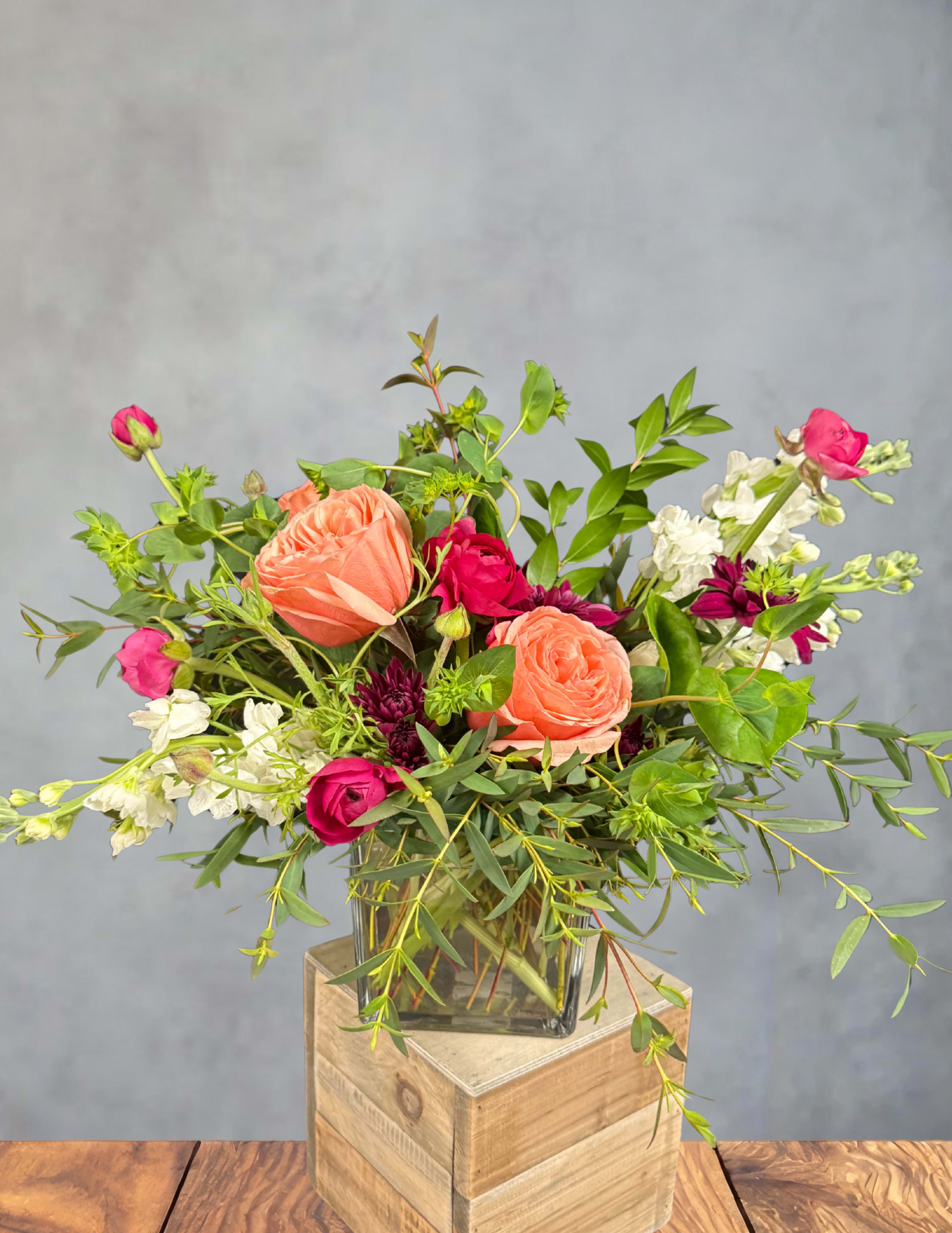 Mixed bouquet of peach and pink roses in a glass vase