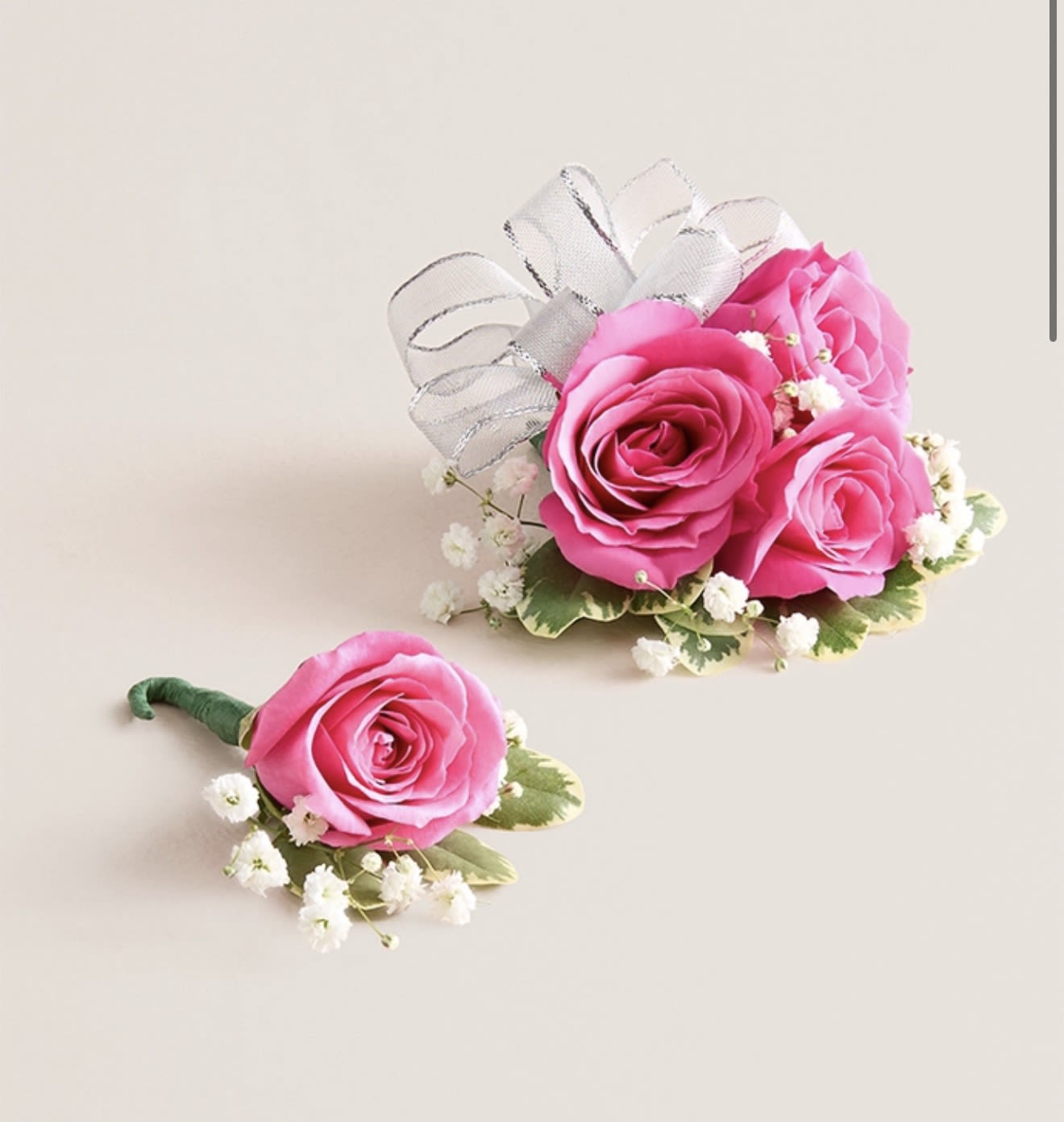 Hot Pink Corsage &amp; Boutonniere Set (Silver Bow) - This striking corsage and boutonniere set, featuring bold hot pink blooms, is thoughtfully designed to pair perfectly, creating a polished and harmonious look for any special occasion. Each piece showcases carefully selected hot pink flowers and accents, offering a vibrant and refined touch that complements your ensemble beautifully.