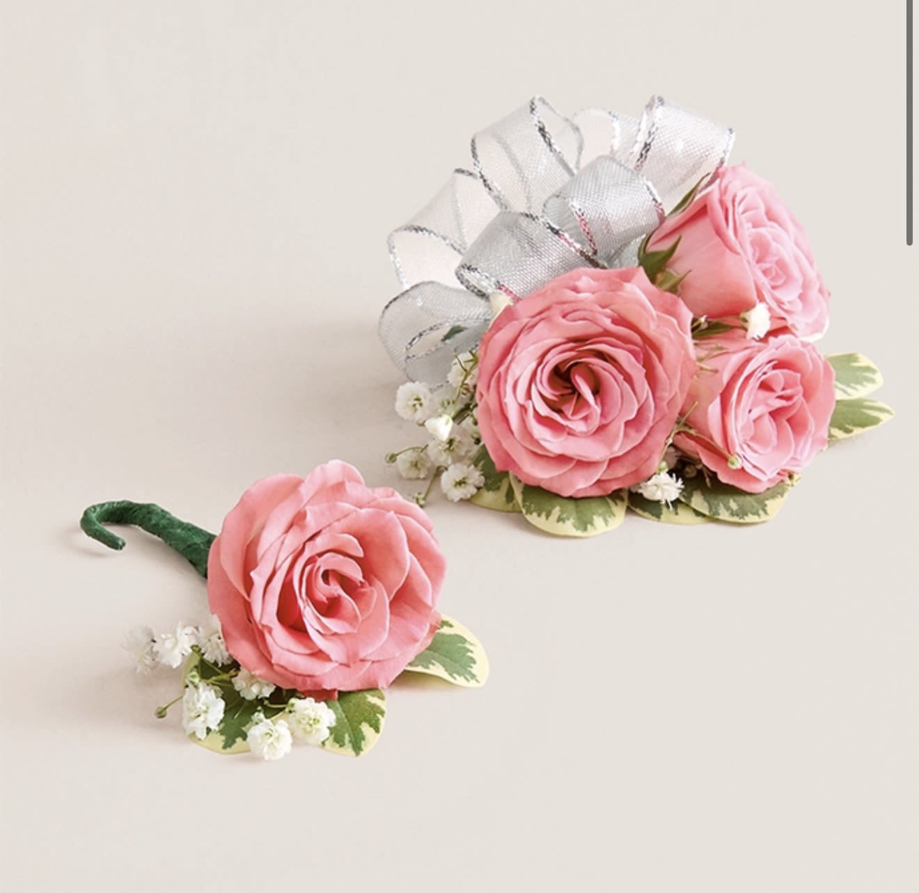 Light Pink Corsage &amp; Boutonniere Set (Silver Bow) - This striking corsage and boutonniere set, featuring delicate light pink blooms, is thoughtfully designed to pair perfectly, creating a polished and harmonious look for any special occasion. Each piece showcases carefully selected light pink flowers and accents, offering a vibrant and refined touch that complements your ensemble beautifully.