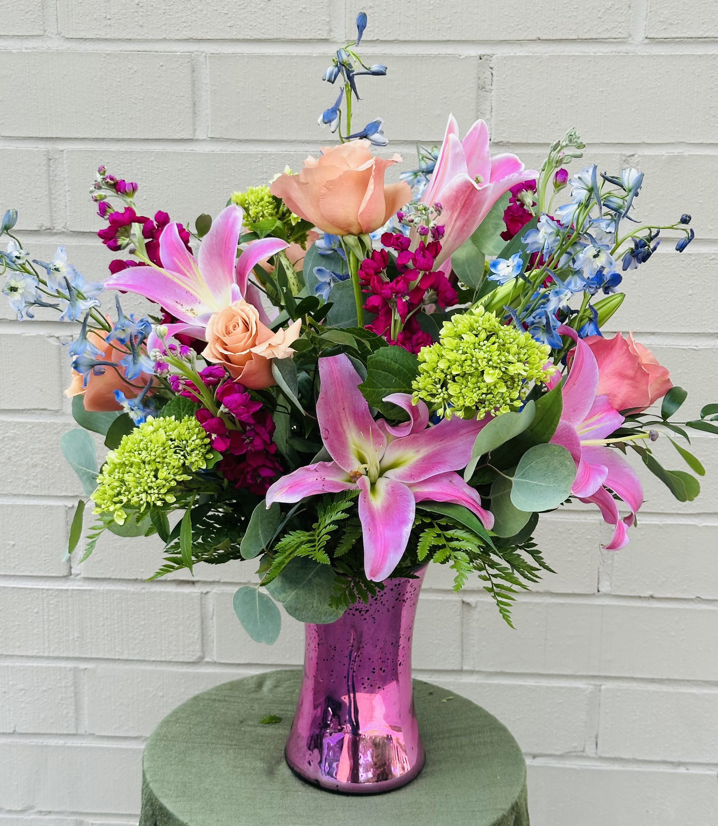 Pink lilies and roses in a metallic pink vase