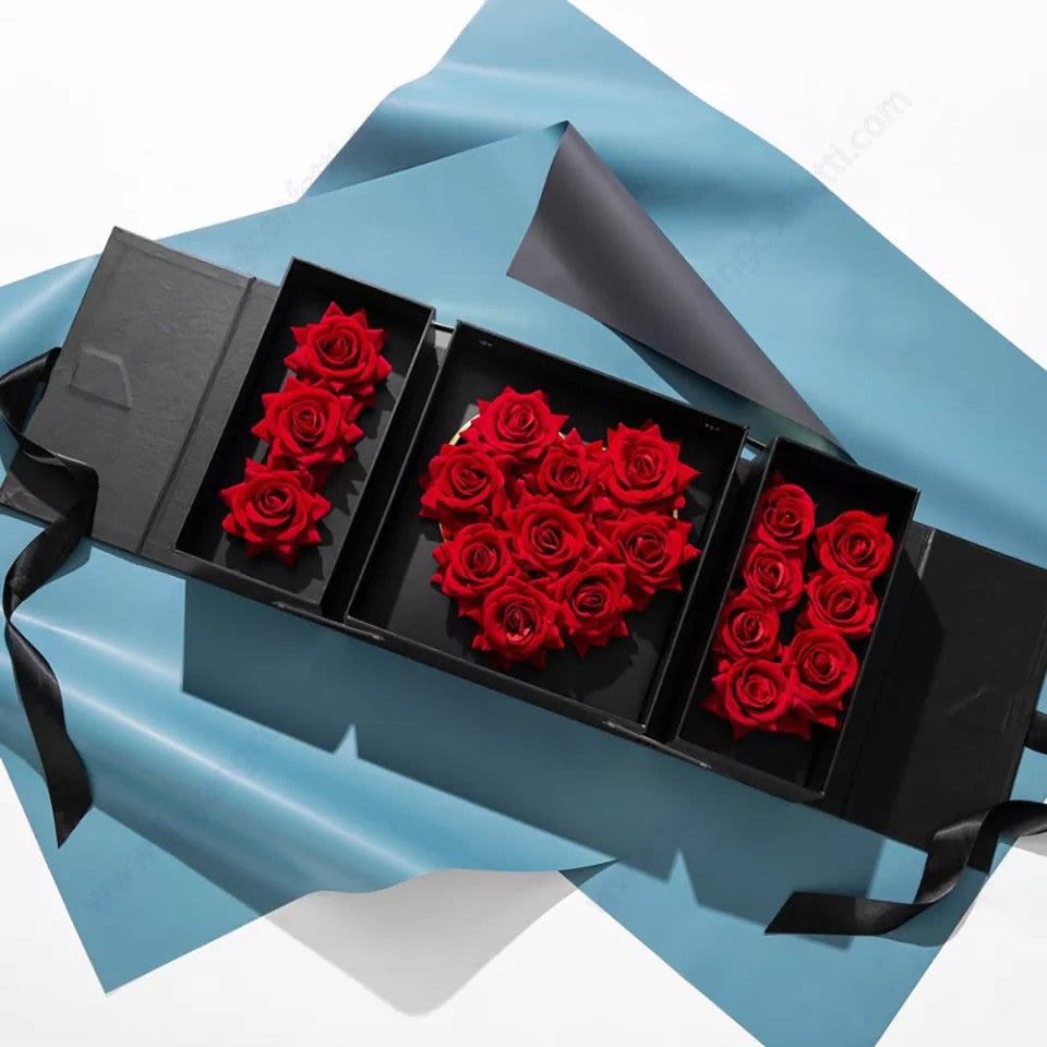 Black gift box with red roses arranged in three compartments