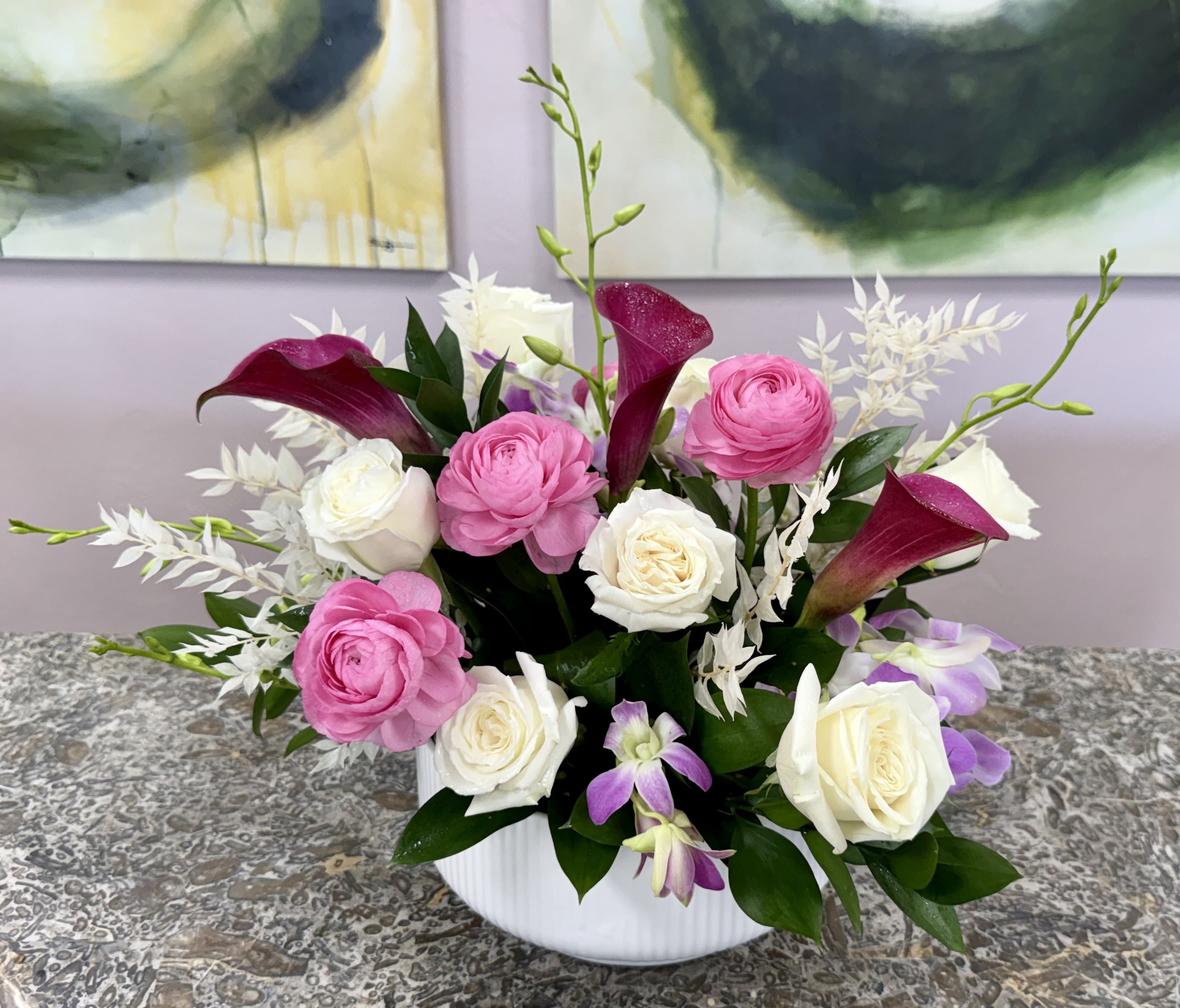 Naples Garden Sonata - A garden-fresh statement that can read either serene or celebratory, this flower arrangement brings together calla lilies, roses, tulips, carnations and orchids for a versatile bouquet perfect for anniversaries, birthdays, or simply to let someone know you're thinking of them. Whether you choose the pale, sculptural composition in a tall white rectangular vase for a calm, modern sympathy or everyday gift, or the bright mixed-color option in a clear glass vase for a joyful celebration, the recipient will feel genuinely seen by the thoughtful, artful design.  *Flowers are subject to substitutions of equal value.