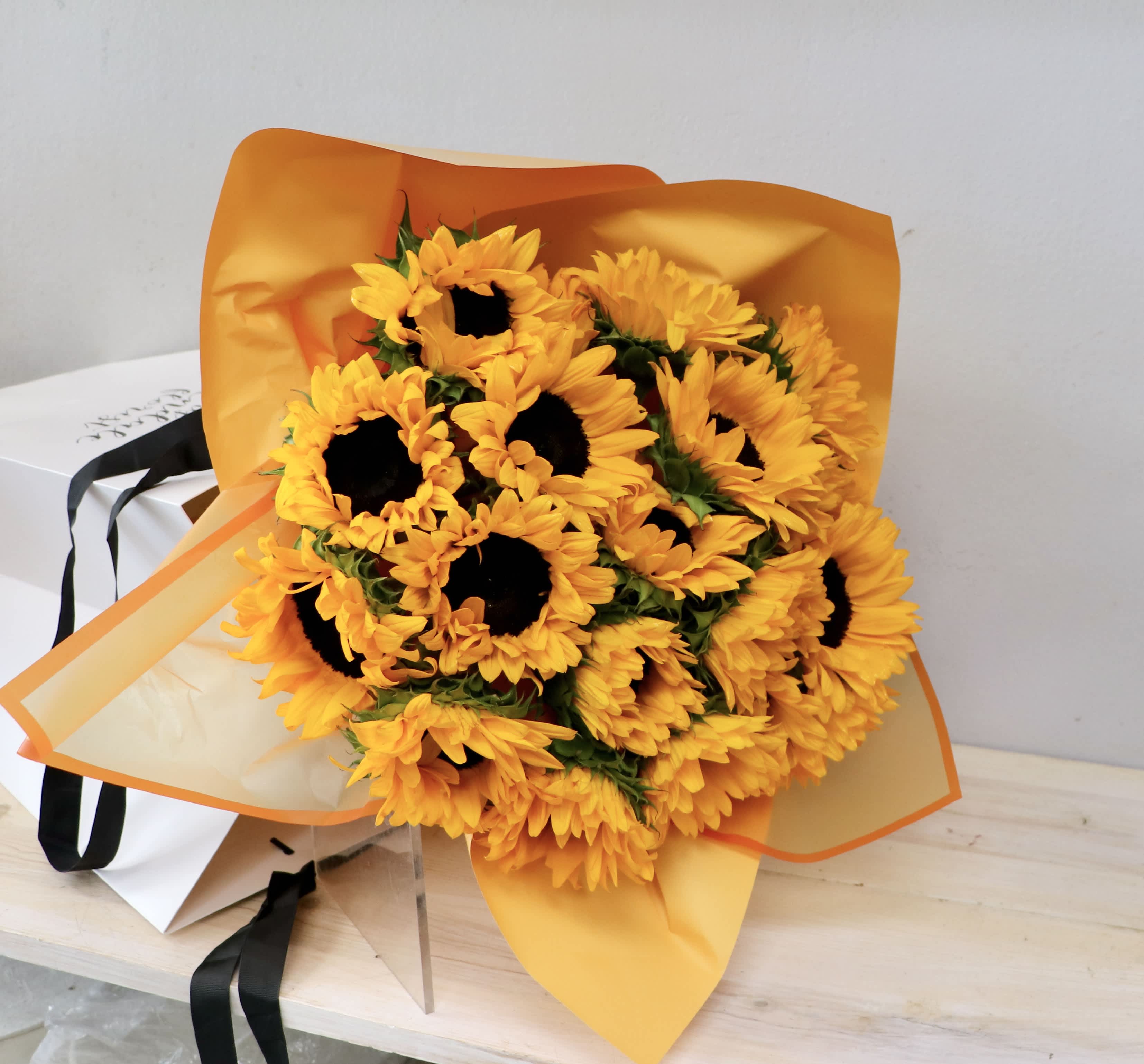 Bouquet of yellow sunflowers wrapped in orange paper
