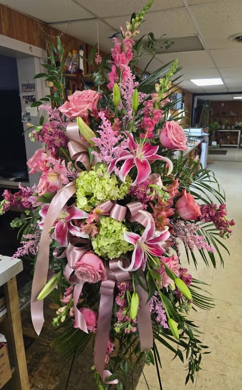 Tall pink floral spray with lilies, roses, and ribbons