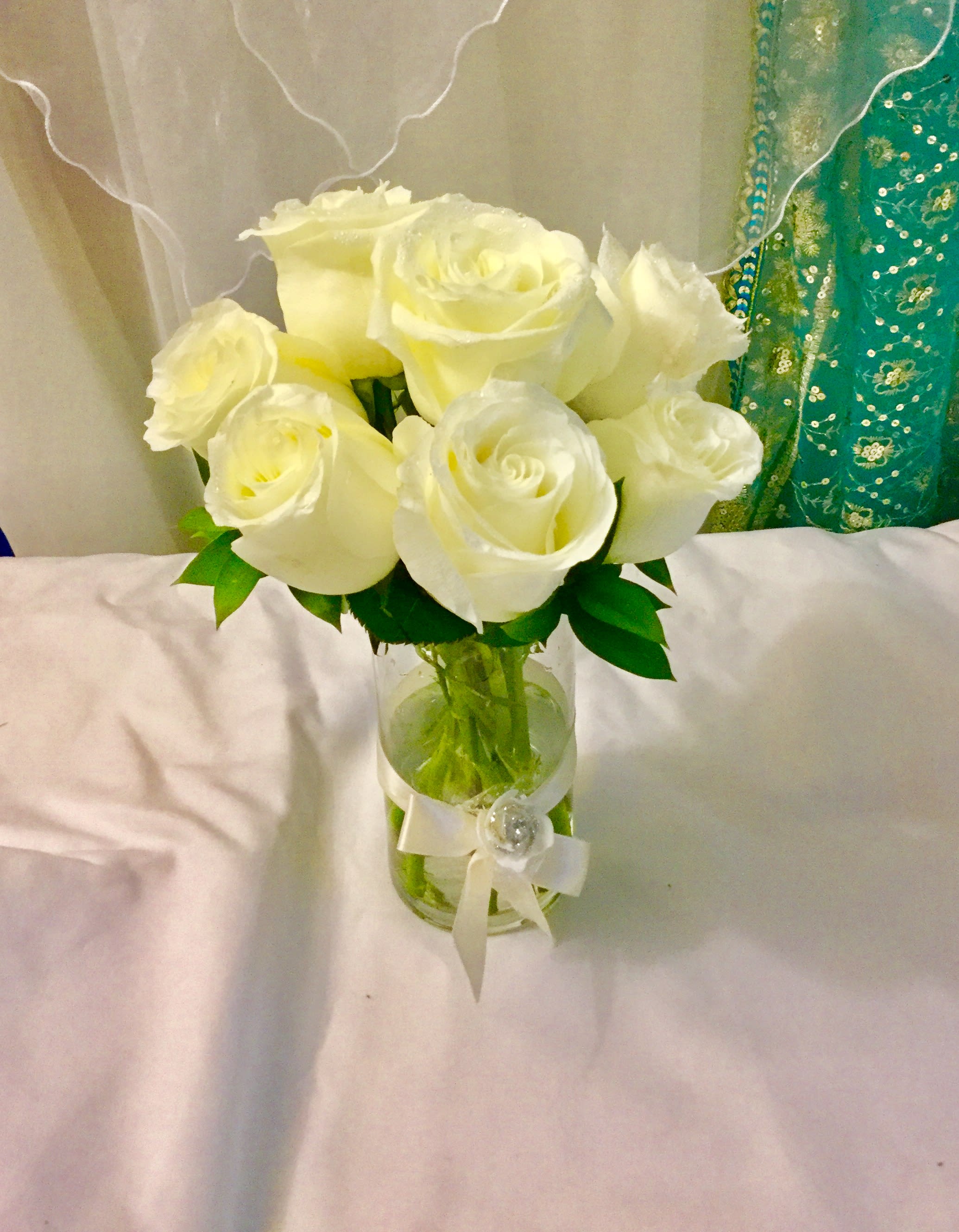 Bouquet of white roses in a glass vase with a ribbon
