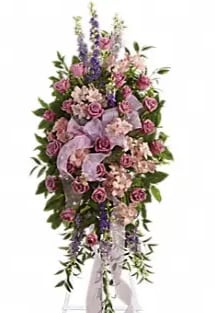 Tall standing floral spray with pink roses and purple flowers on a white ribbon stand