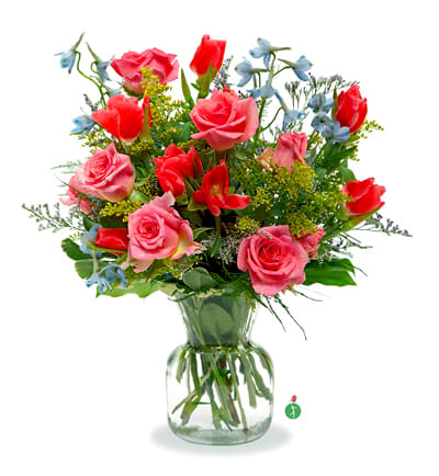 Mixed bouquet of pink and red roses with blue flowers in a glass vase