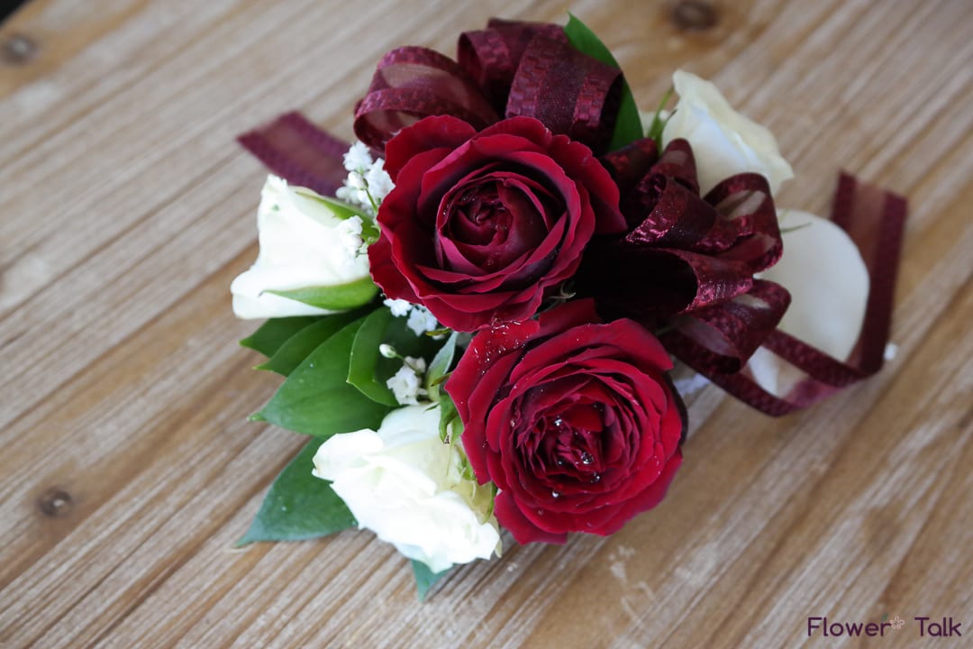 Small bouquet of red and white roses with burgundy ribbon