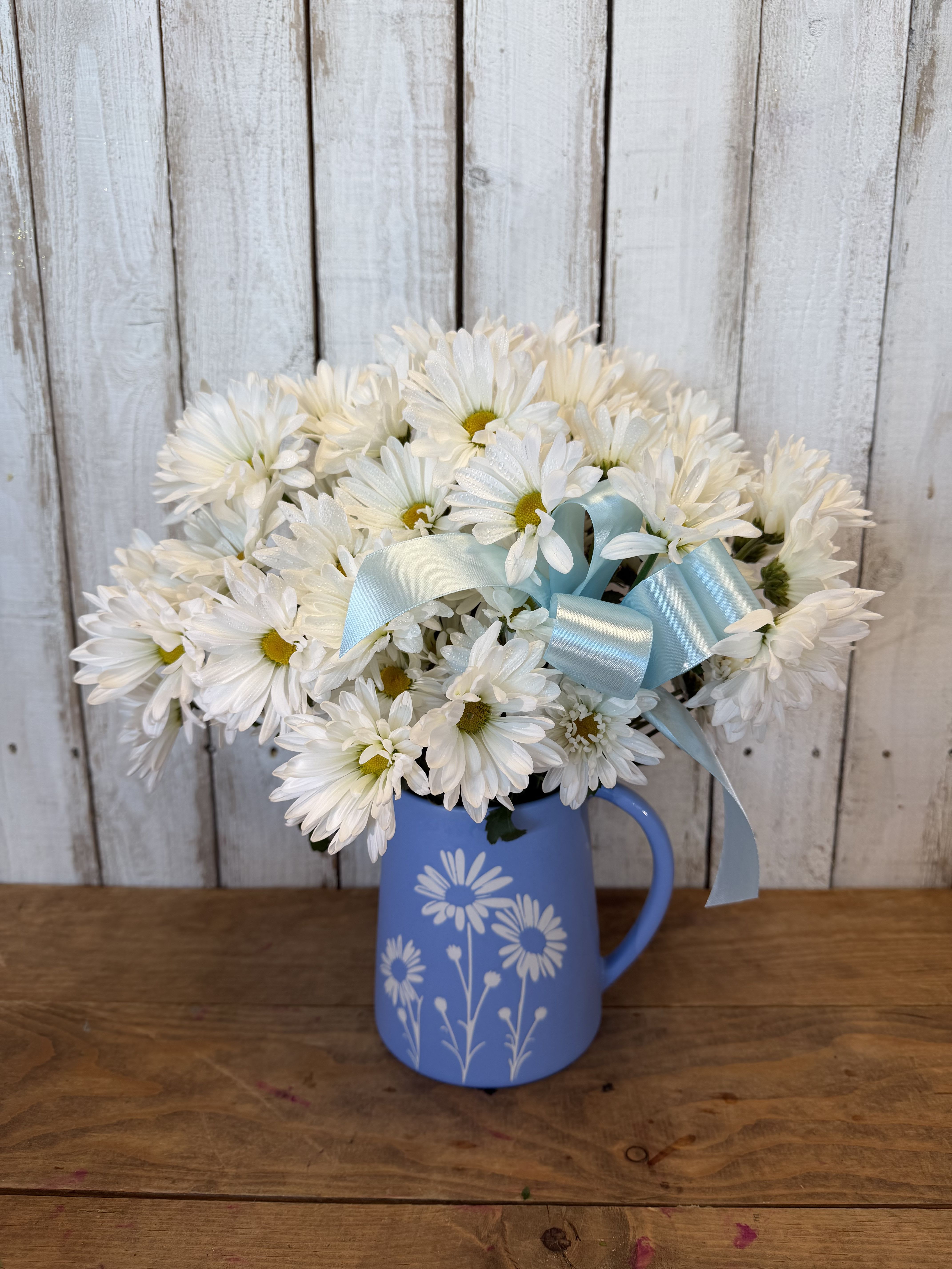 hello bestie  - Bright, cheerful, and full of charm, our “It’s a Daisy Day” arrangement is designed to bring an instant smile. Featuring fresh white daisies arranged in a keepsake blue pitcher, this sweet and simple bouquet is perfect for saying thinking of you, get well soon, or even a soft and heartfelt I love you.  With its light, happy feel and timeless beauty, this arrangement makes a thoughtful gift for any occasion from birthdays to everyday moments that deserve a little sunshine. Handcrafted by our floral designers and available for same day flower delivery in Rancho Cucamonga and throughout the Inland Empire, this delightful daisy bouquet is ready to brighten someone’s day. 