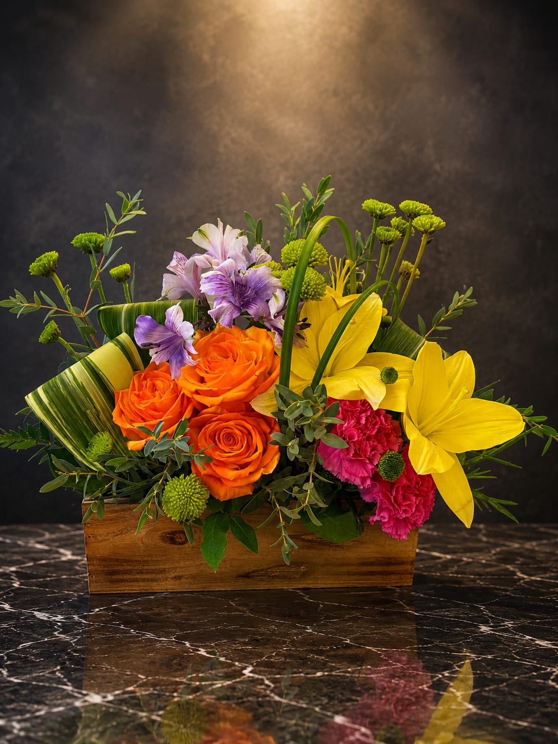 Bright mixed flower arrangement in a wooden box with orange roses and yellow lilies
