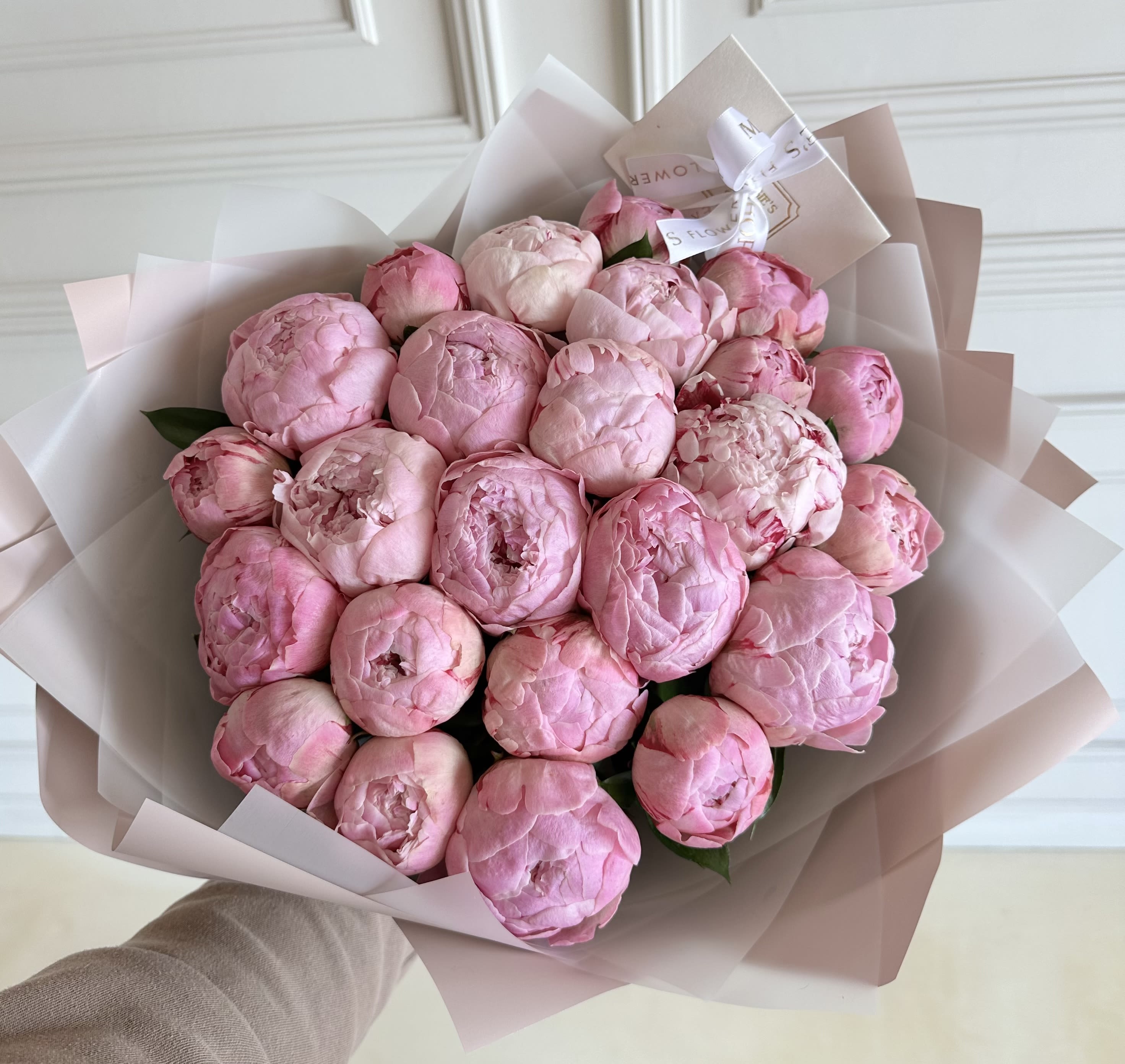 Bouquet of pink peonies wrapped in pale paper