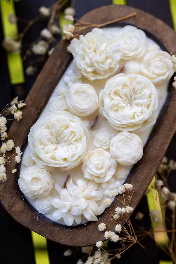 White floral arrangement in a wooden oval tray with small filler flowers
