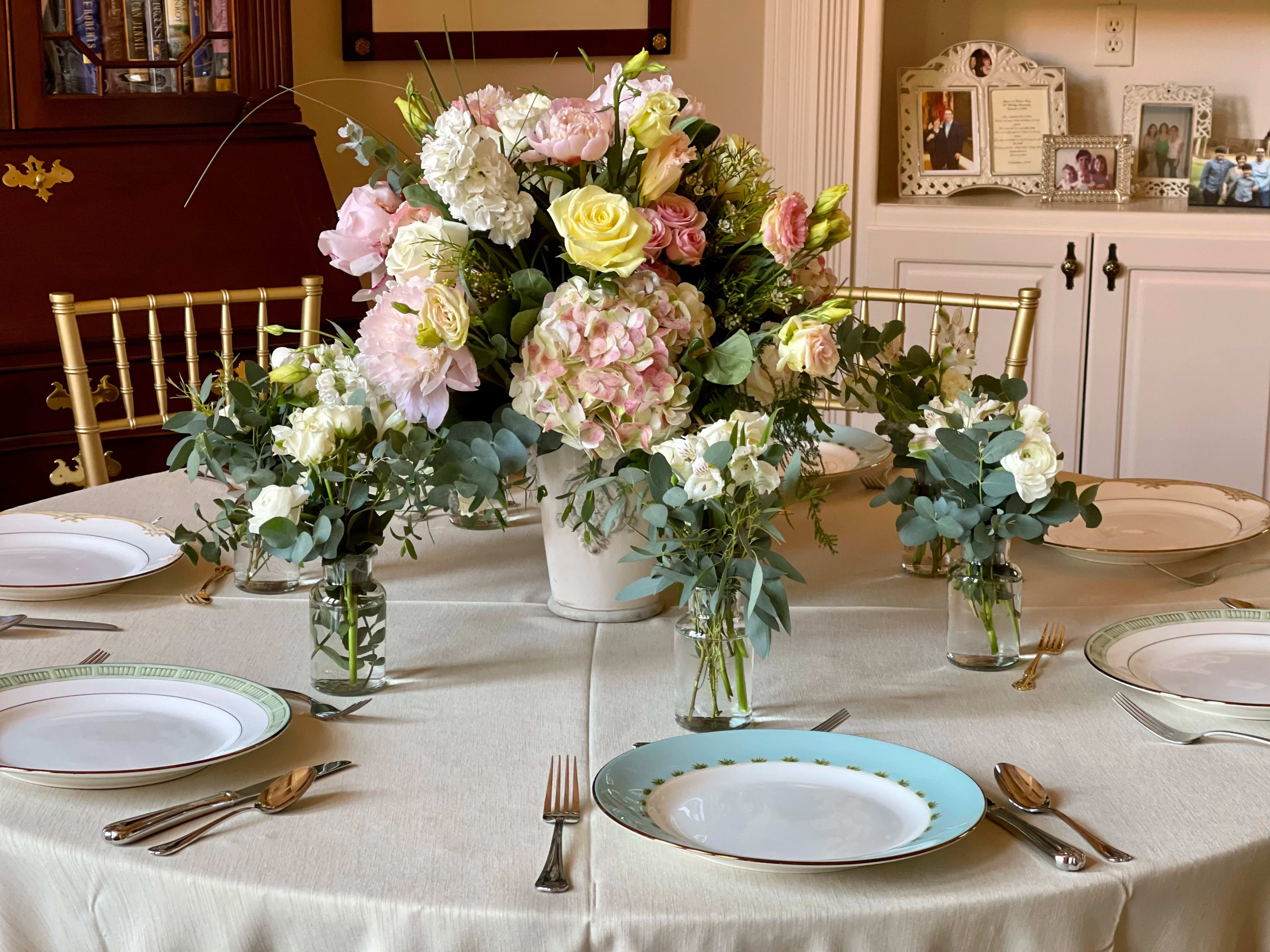 Pastel floral centerpiece with roses and hydrangeas on a dining table