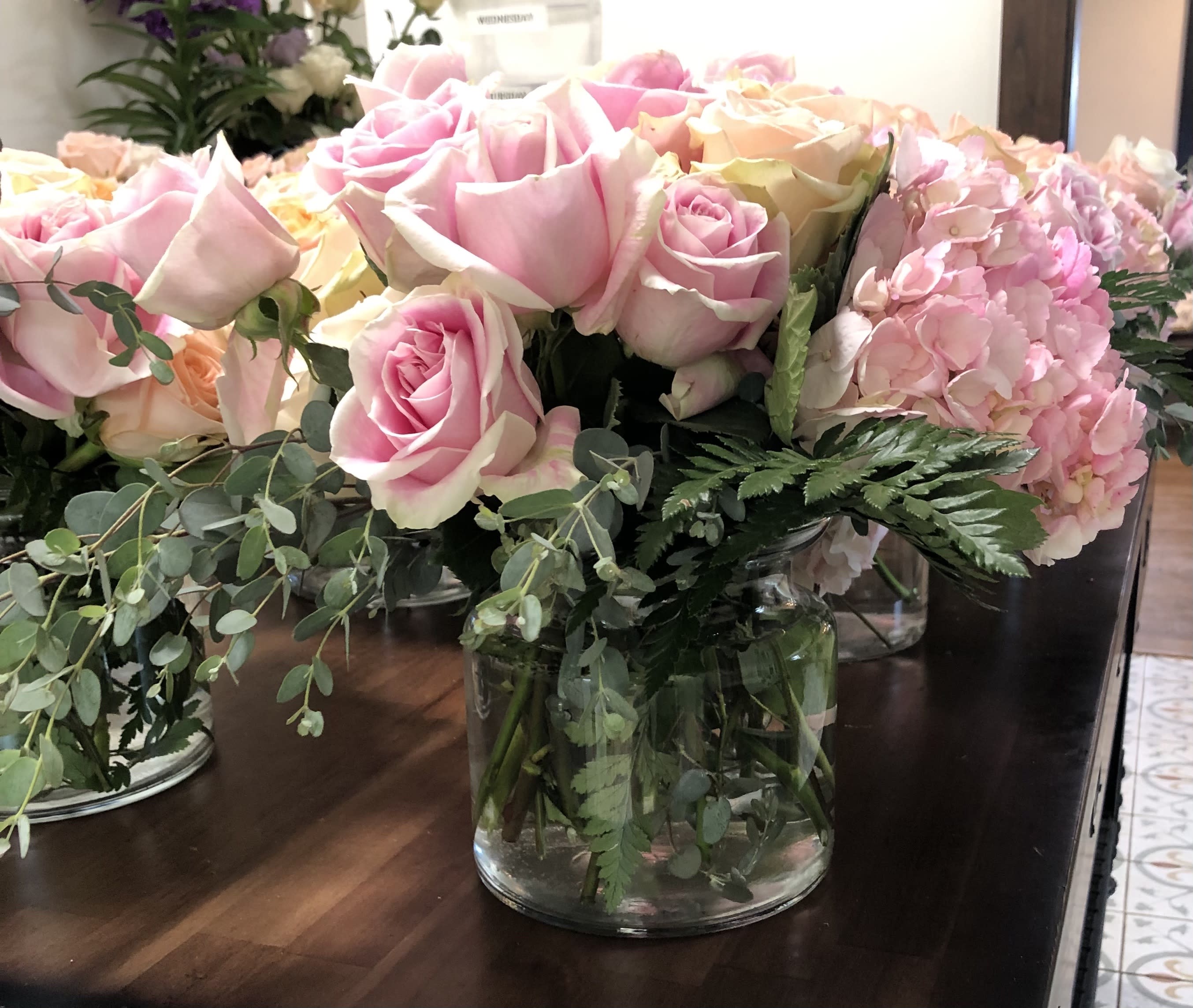 Pink and cream roses with hydrangeas in a glass vase