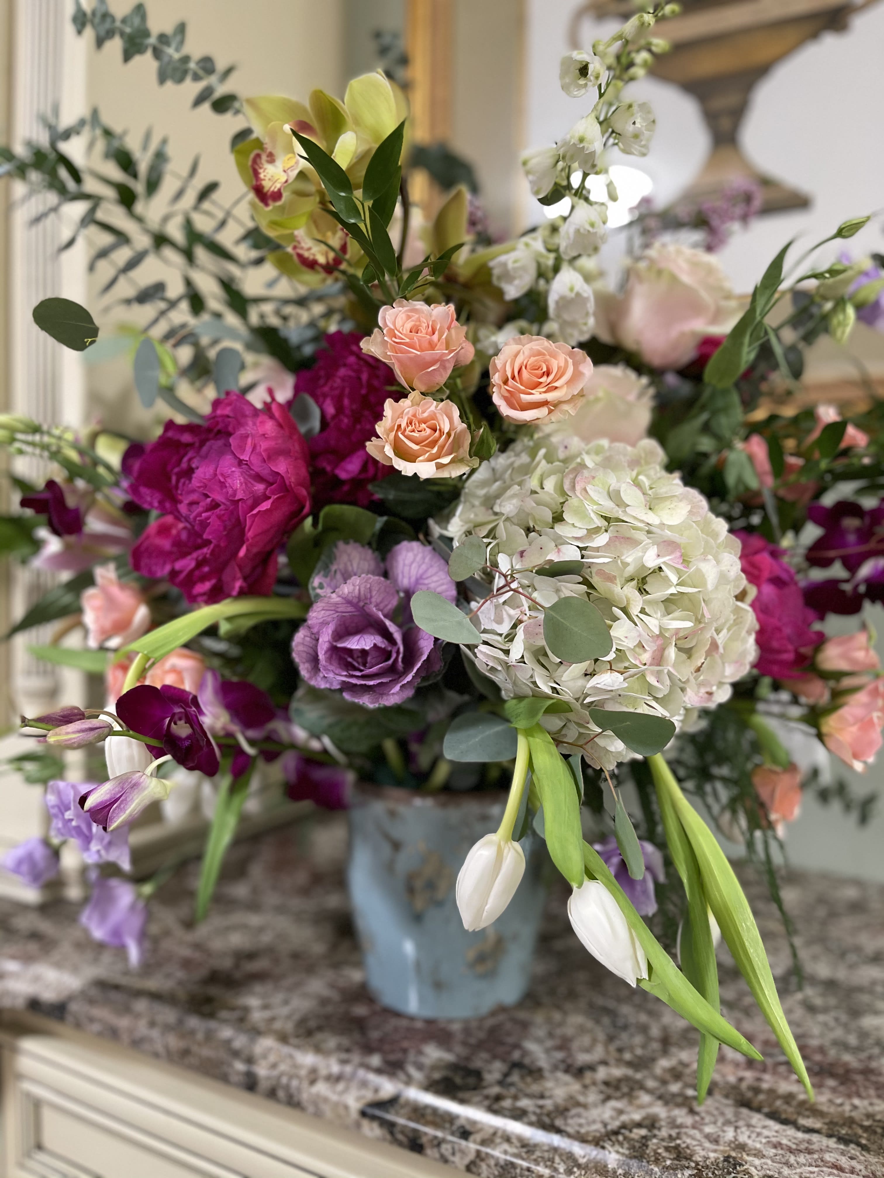 Mixed bouquet in a blue vase with pink, white, and purple blooms