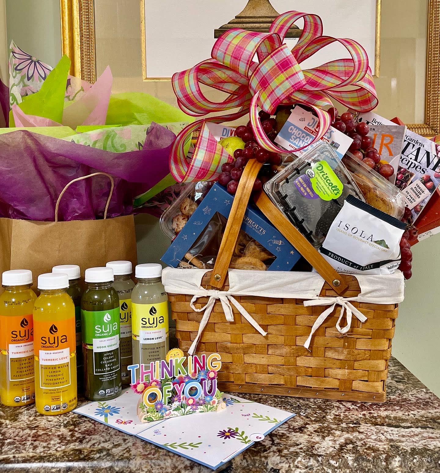 Gift basket with snacks, juice bottles, and a large plaid ribbon bow