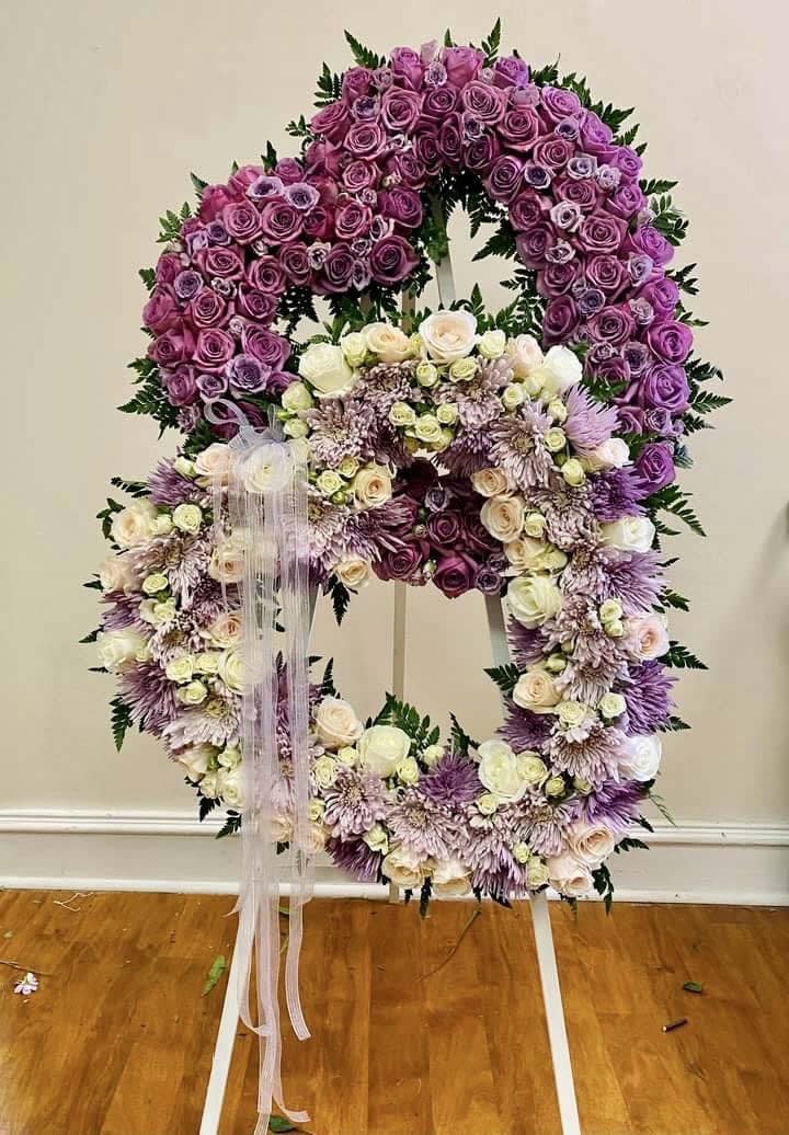 Large floral wreath on an easel with purple and white flowers