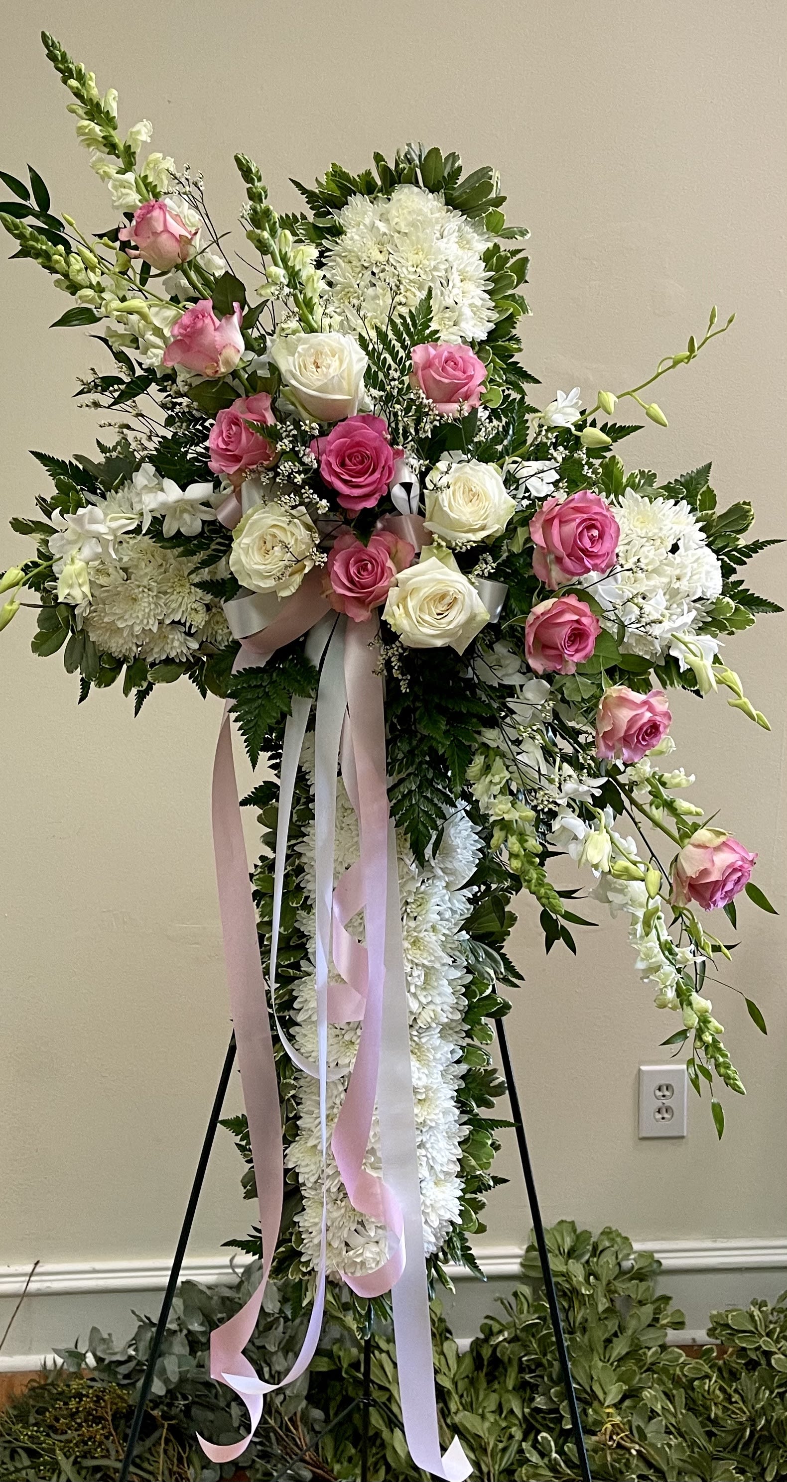 Standing floral cross with pink and white roses and white blooms