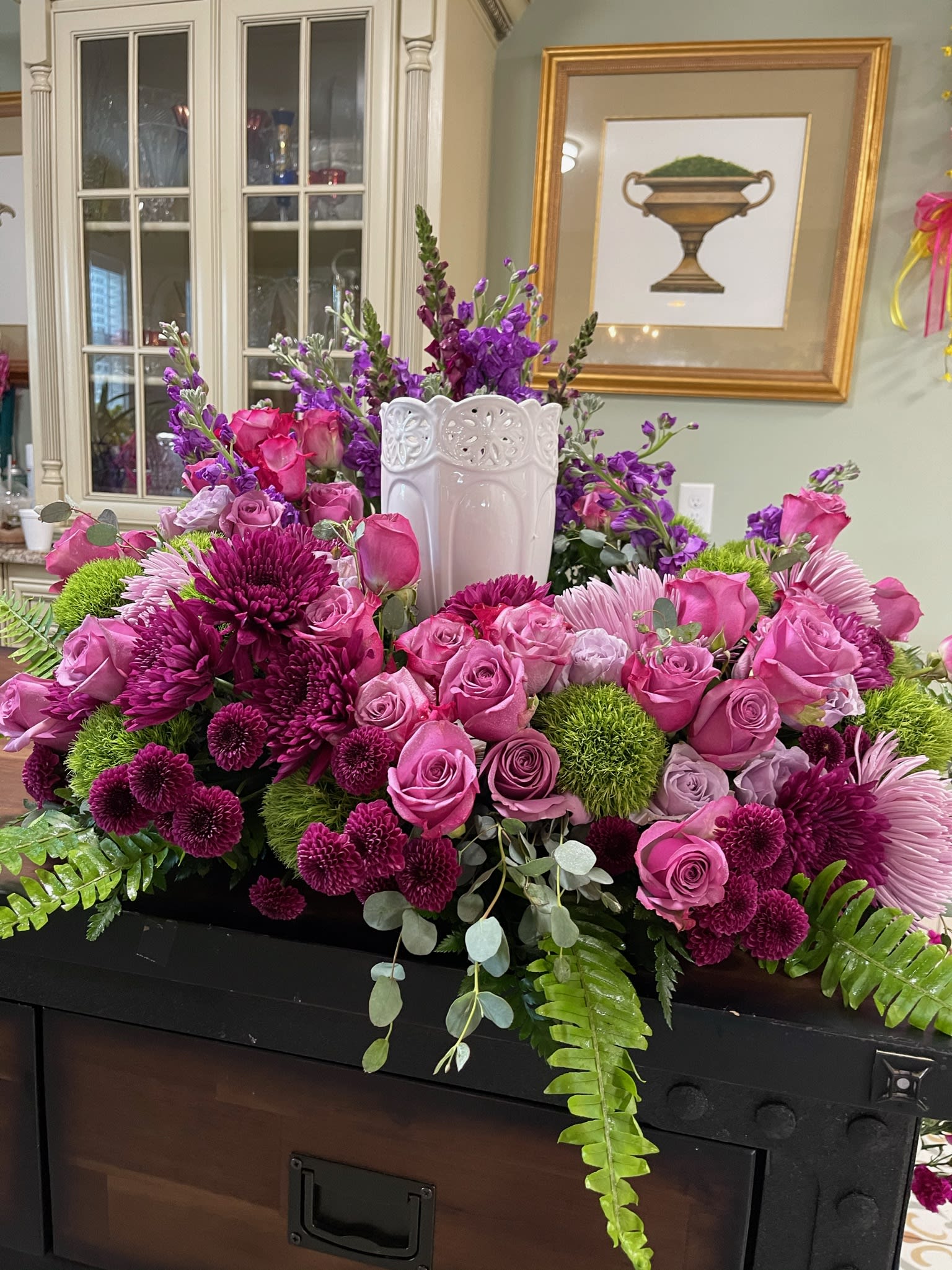Large pink and purple floral arrangement in a white vase