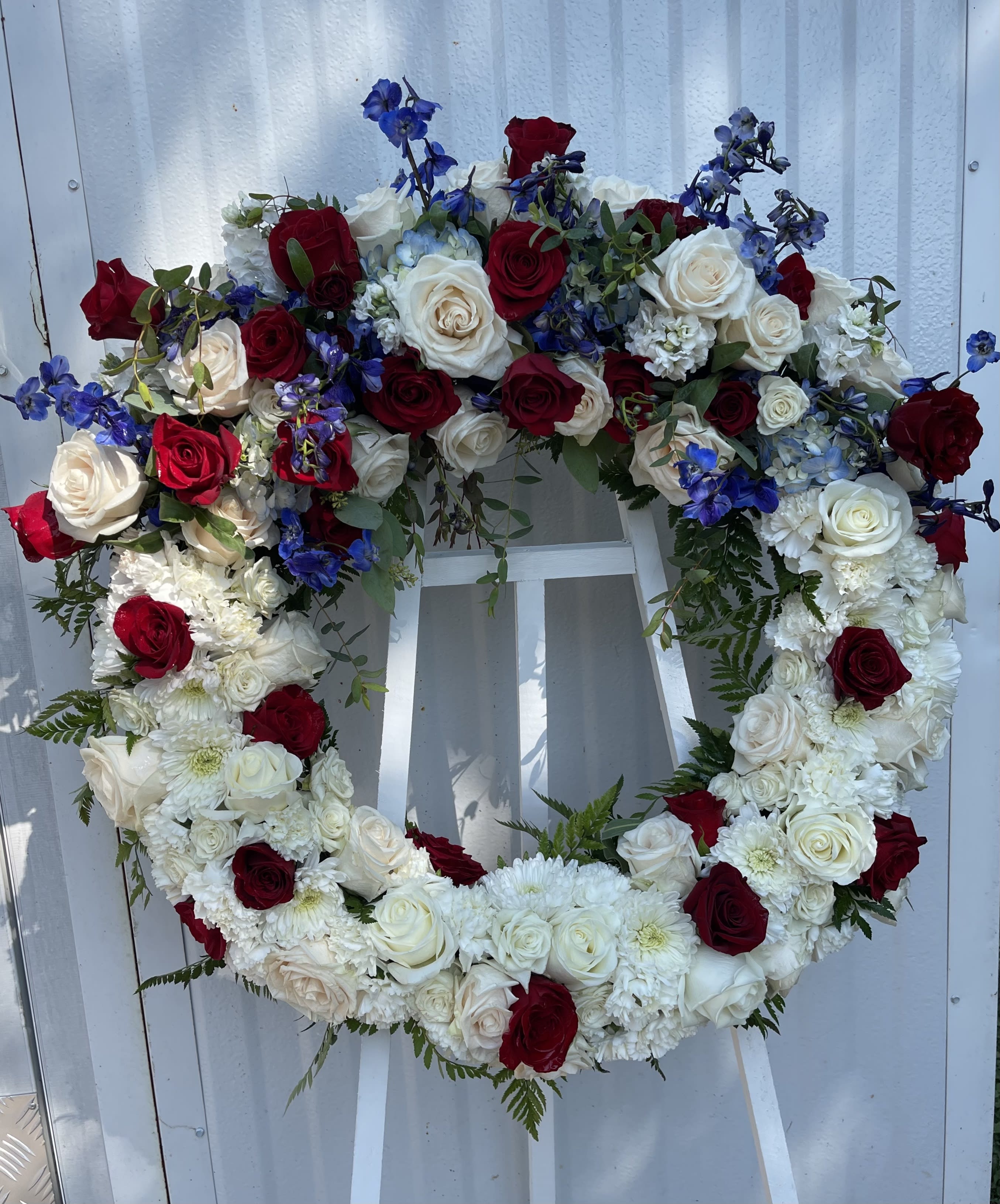 Patriotic Wreath - A perfect way to honor their beliefs and actions, this red, white, and blue wreath is a tribute to those who loved their country. 