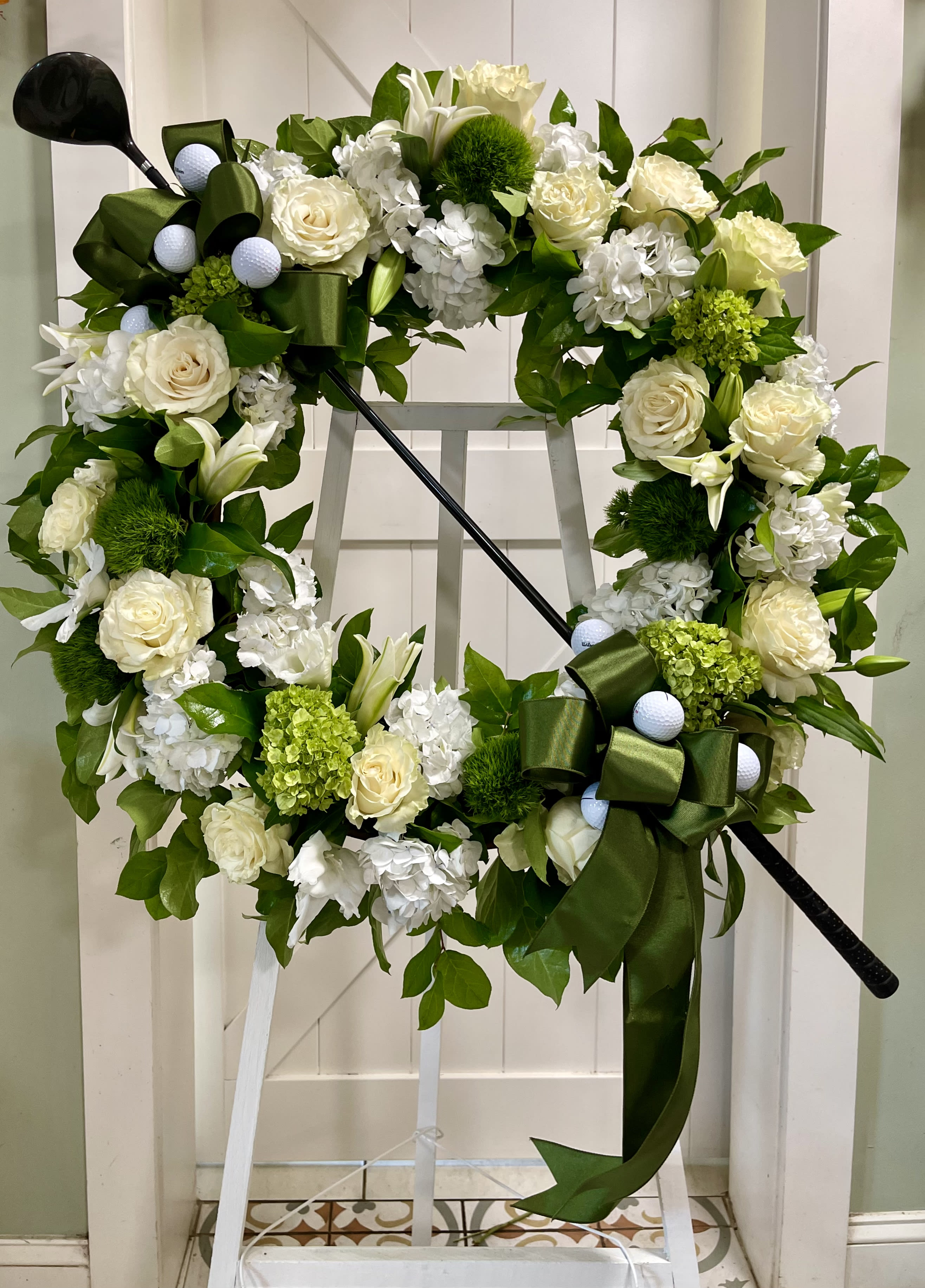 Floral wreath with white roses and lilies on a stand
