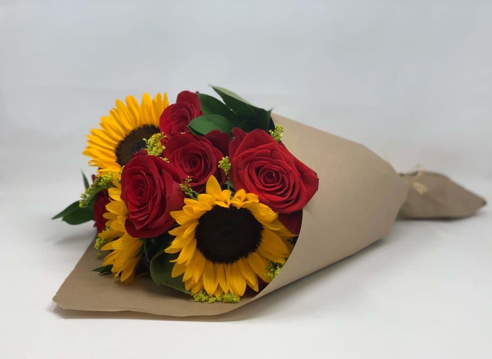 Bouquet of red roses and yellow sunflowers wrapped in brown paper