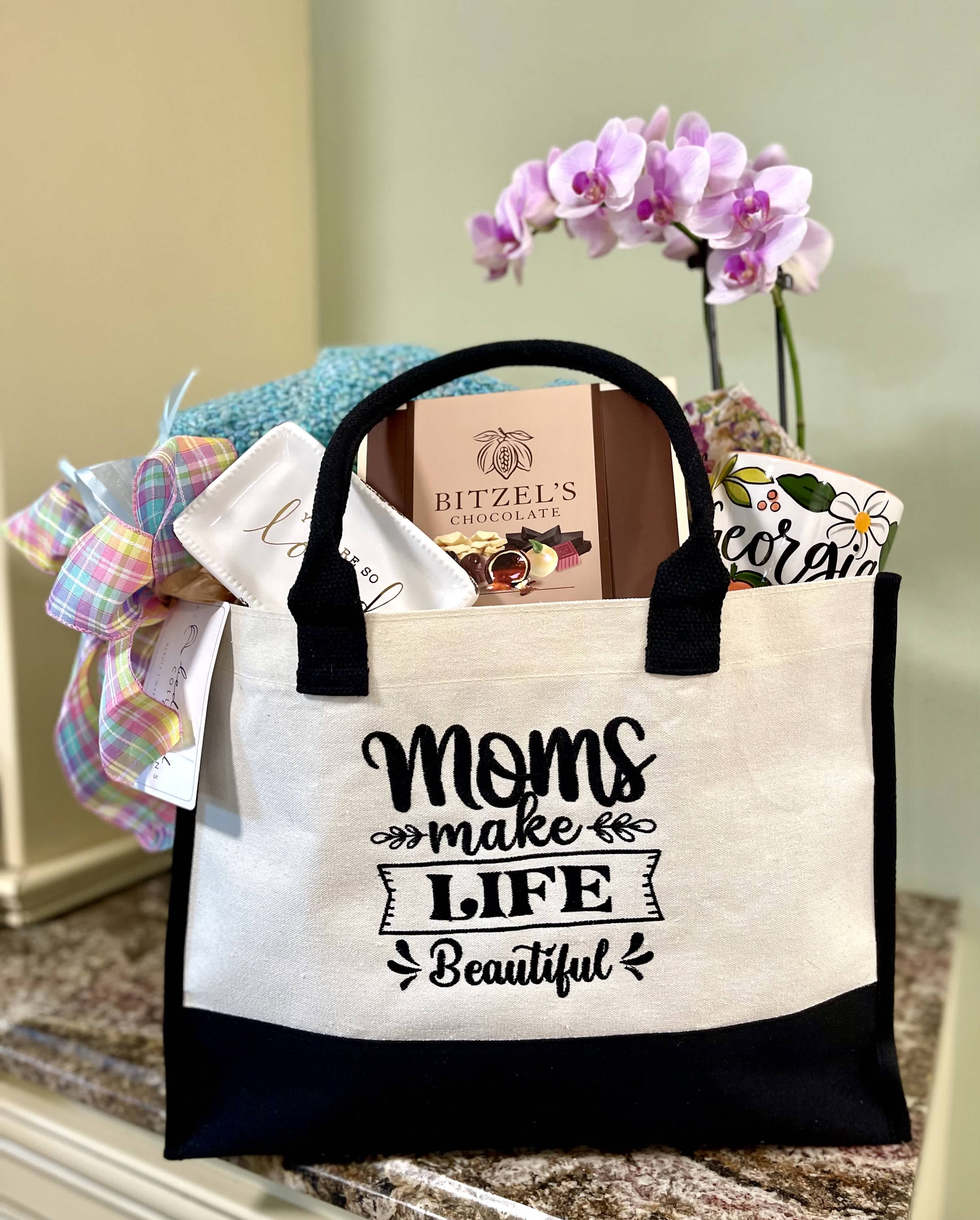 Moms Make Life Beautiful Tote Bundle - The perfect present for the Mom in your life that makes your life more beautiful.  The "Moms Make Life Beautiful" tote is packed with a variety of Mom favorites including florals, chocolates, candles, soaps, specialty items, jams, throws and can be customized with her favorites.