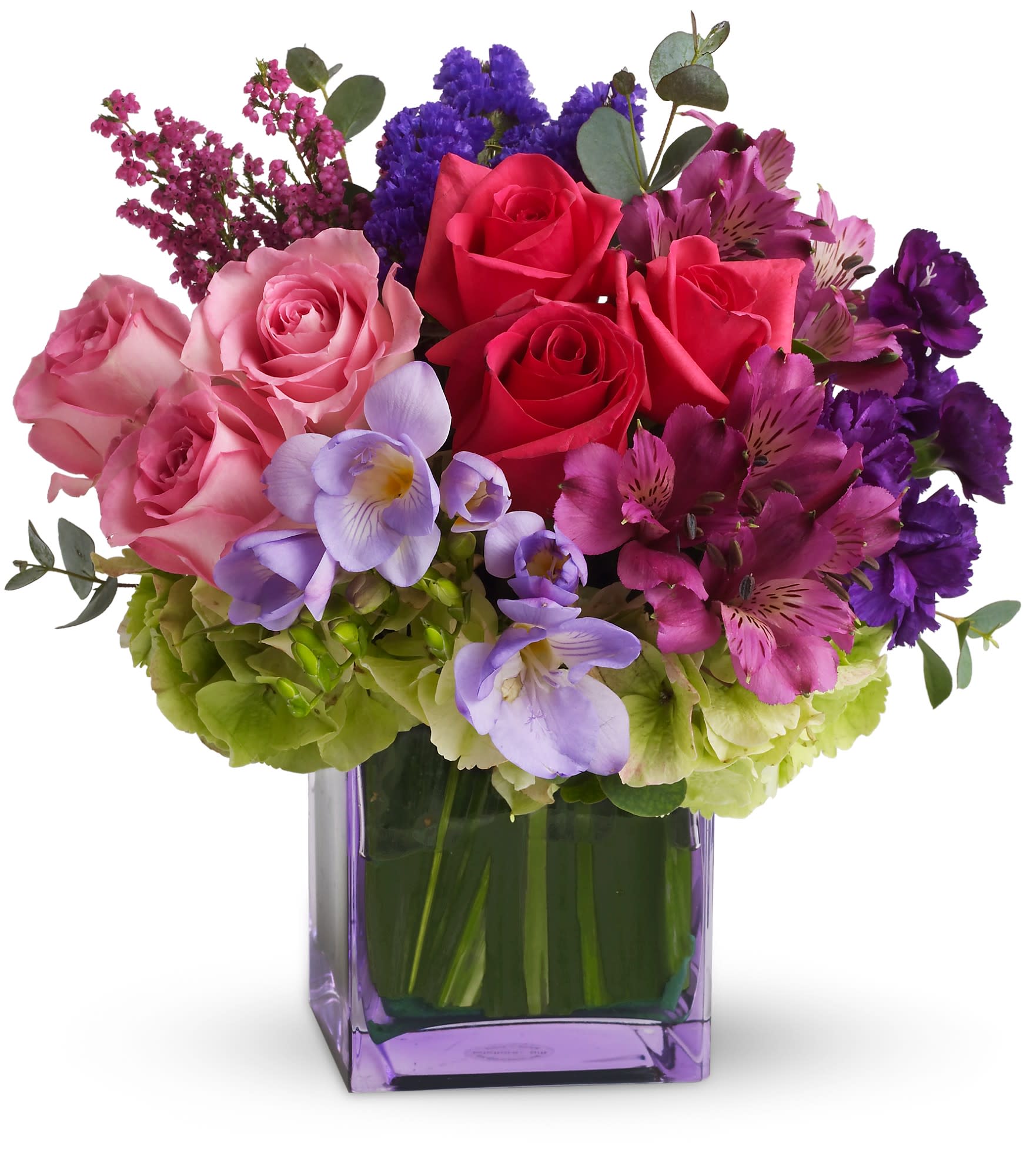 Mixed bouquet of pink and purple flowers in a purple glass vase