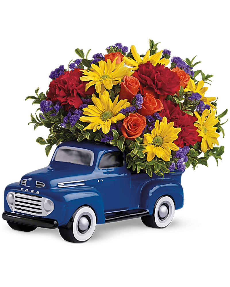 Blue truck-shaped planter filled with red, yellow, and orange flowers