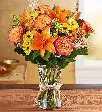 Orange and yellow mixed bouquet in a clear glass vase