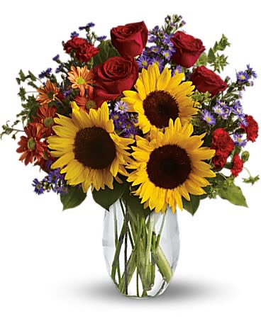 Bouquet of sunflowers, red roses, and purple filler flowers in a glass vase