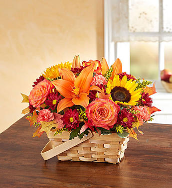 Basket arrangement of orange lilies, roses, sunflowers, and mums