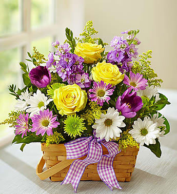Basket of yellow roses, purple flowers, and white daisies with a plaid ribbon