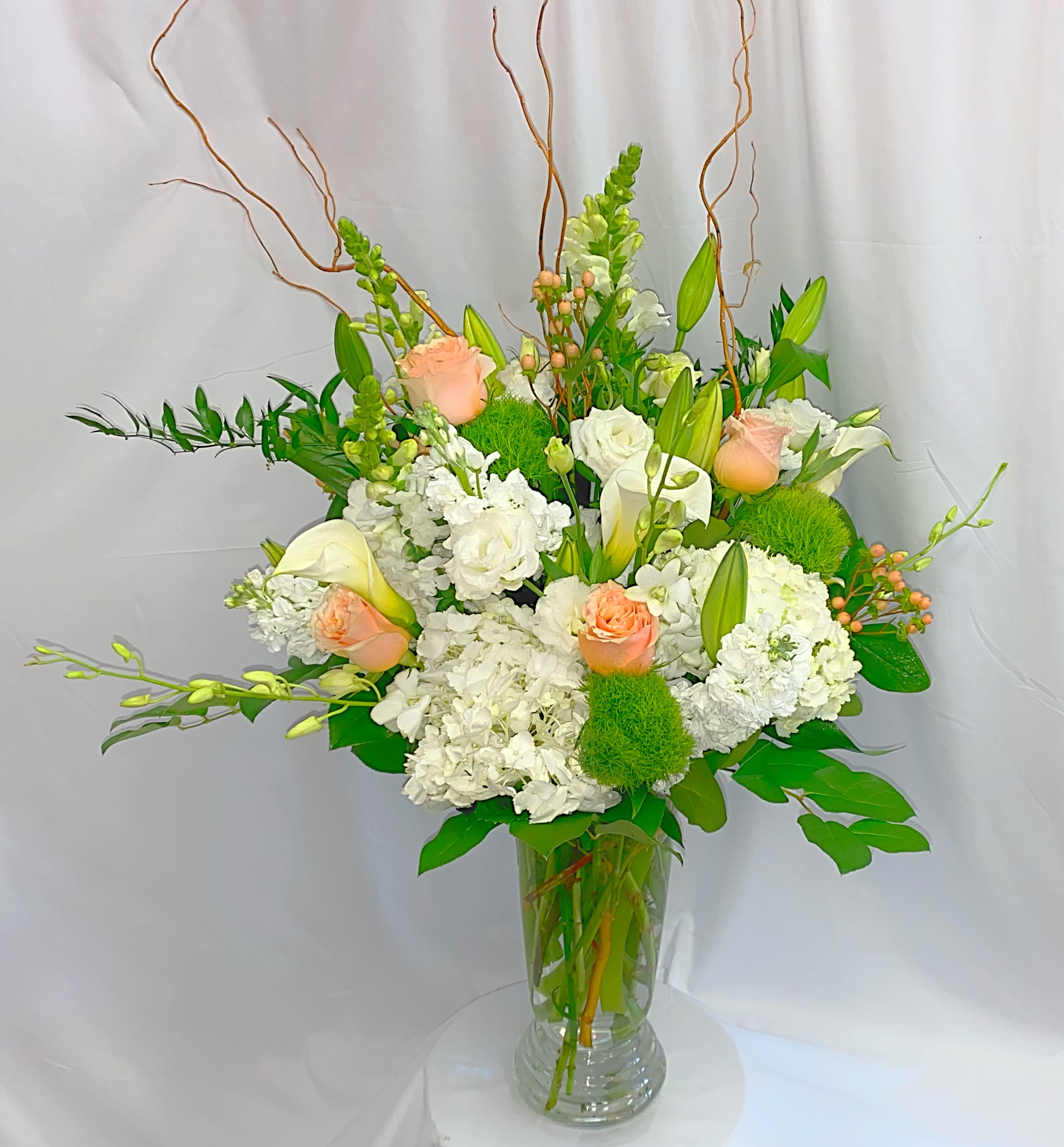 White and peach floral arrangement in a clear glass vase