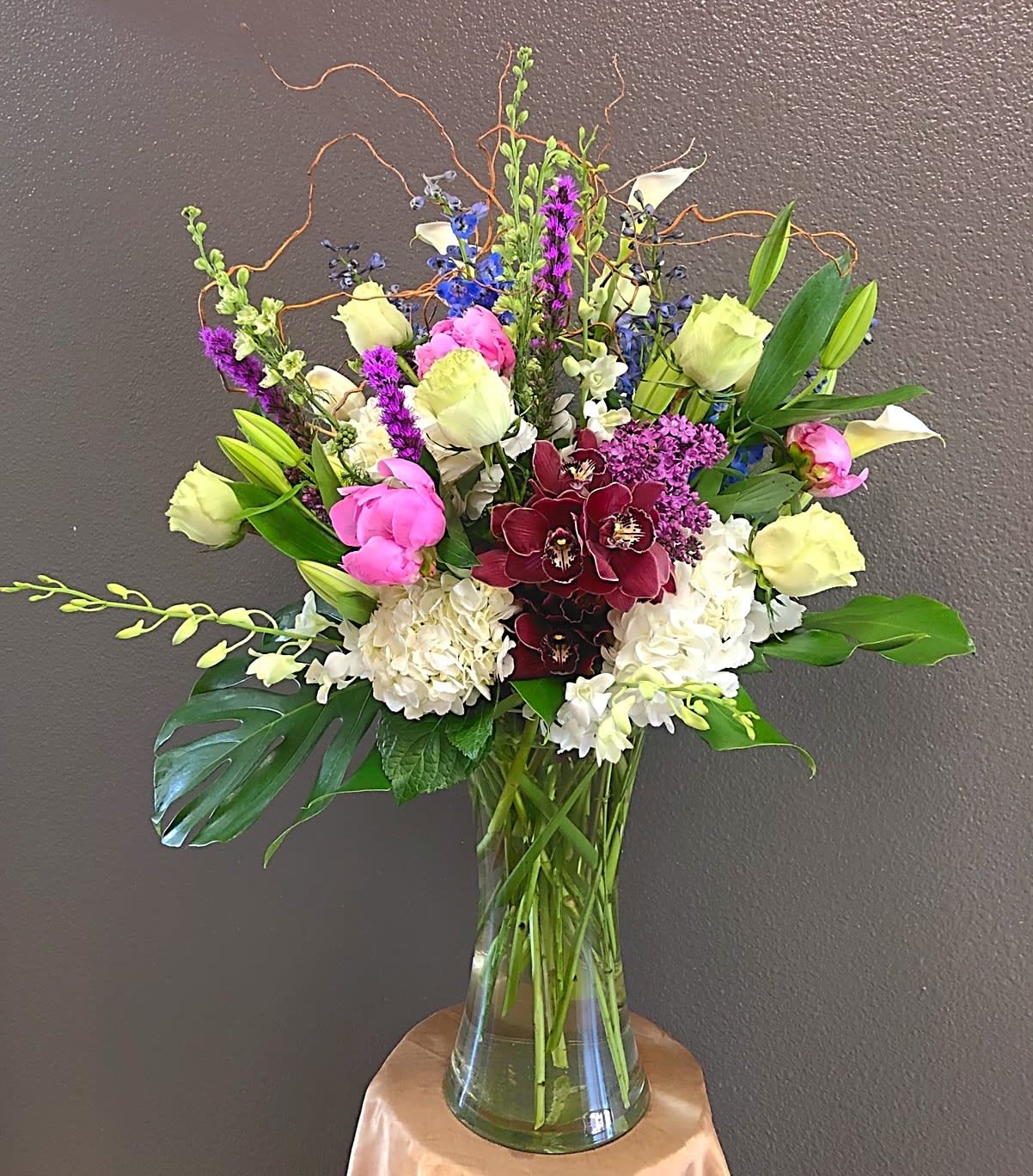 Mixed bouquet in a clear glass vase with pink, white, purple, and blue flowers