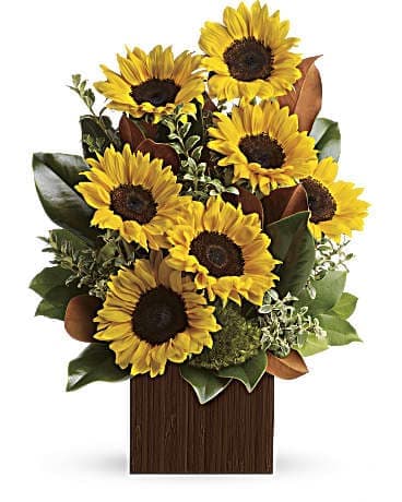 Sunflower arrangement in a wooden box with green foliage