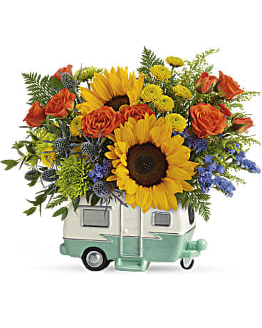 Sunflower and orange rose arrangement in a small camper-shaped vase