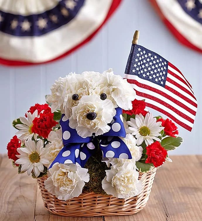 Flower arrangement shaped like a dog with an American flag