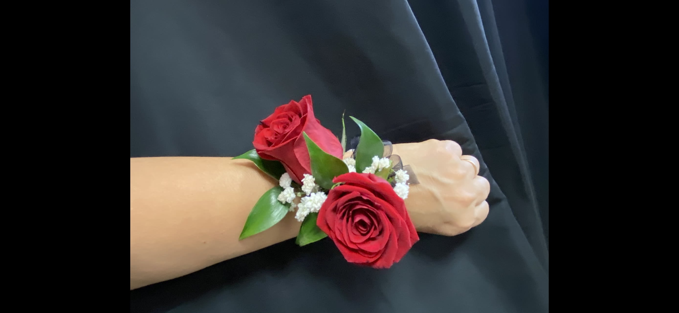 Red rose wrist corsage with white filler flowers