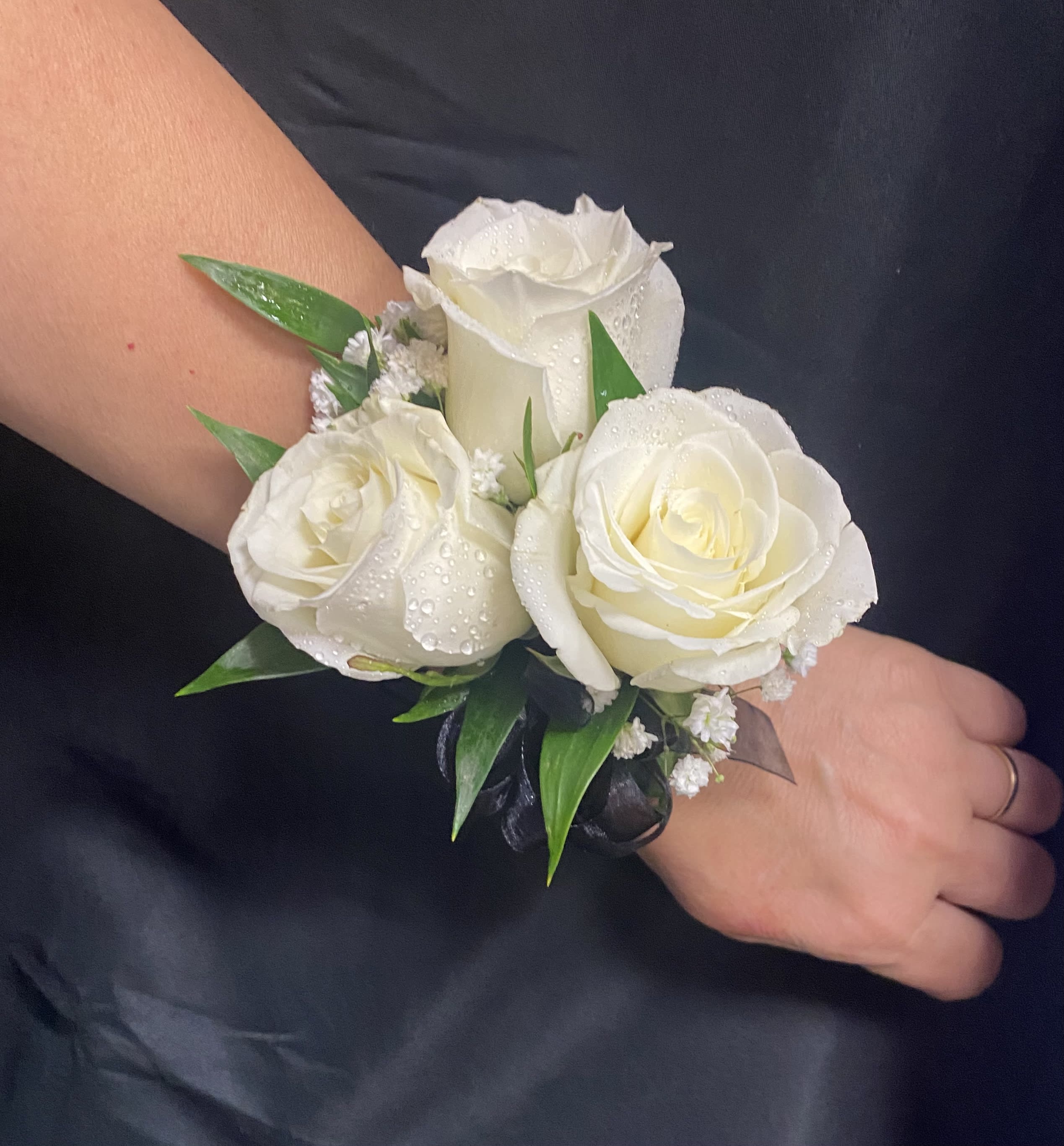 White rose wrist corsage with green leaves